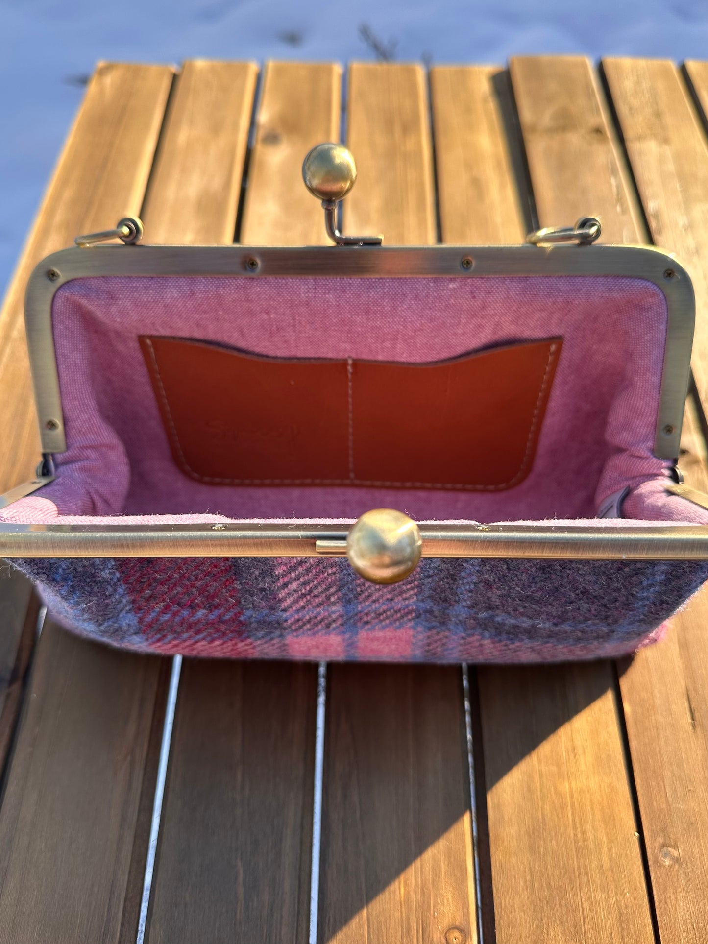 Interior of Pink & Blue Plaid Harris Tweed® kiss lock purse. Pink Linen lining complements tweed exterior. Bronze hardware, card slots, fits phone and small items.