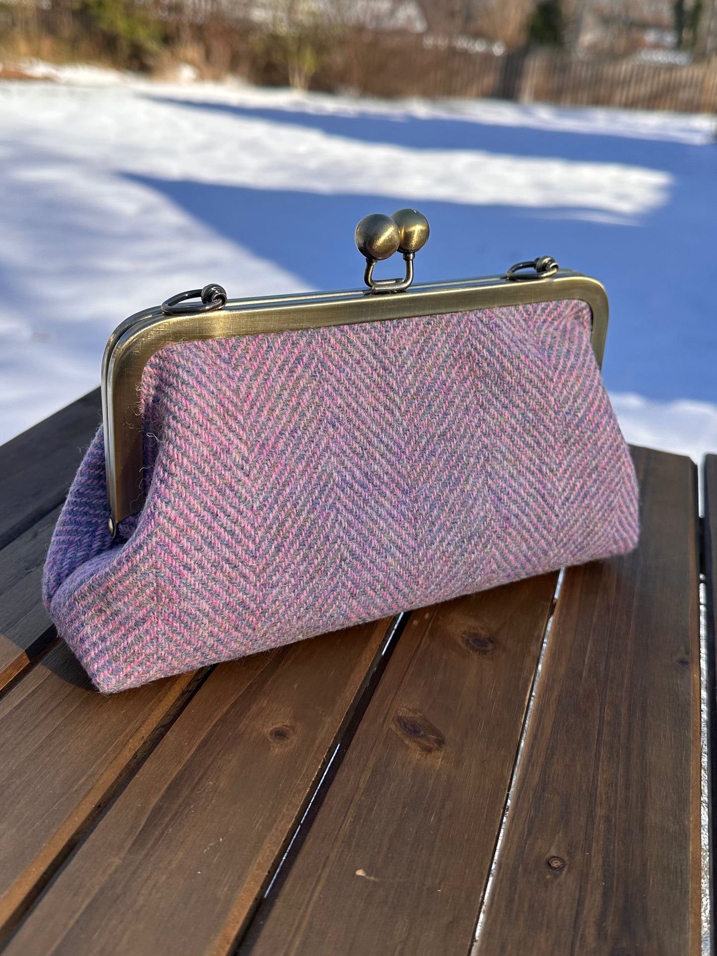 Harris Tweed® kiss lock purse in Pink & Blue Wide Herringbone with bronze hardware. Wear as a clutch, attach chain for shoulder or crossbody wear. Holds phone, cards, and small items. Timeless design handcrafted in Maryland.