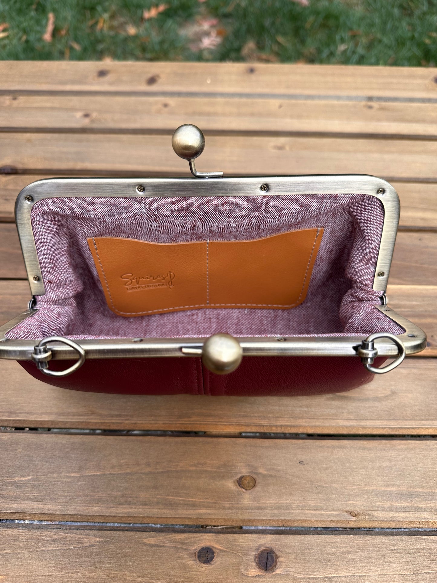 Interior of Nappa Henna leather kiss lock purse with Burgundy Print lining. Includes 2 card slots and space for phone and essentials. Compact and functional design. Made in Maryland.