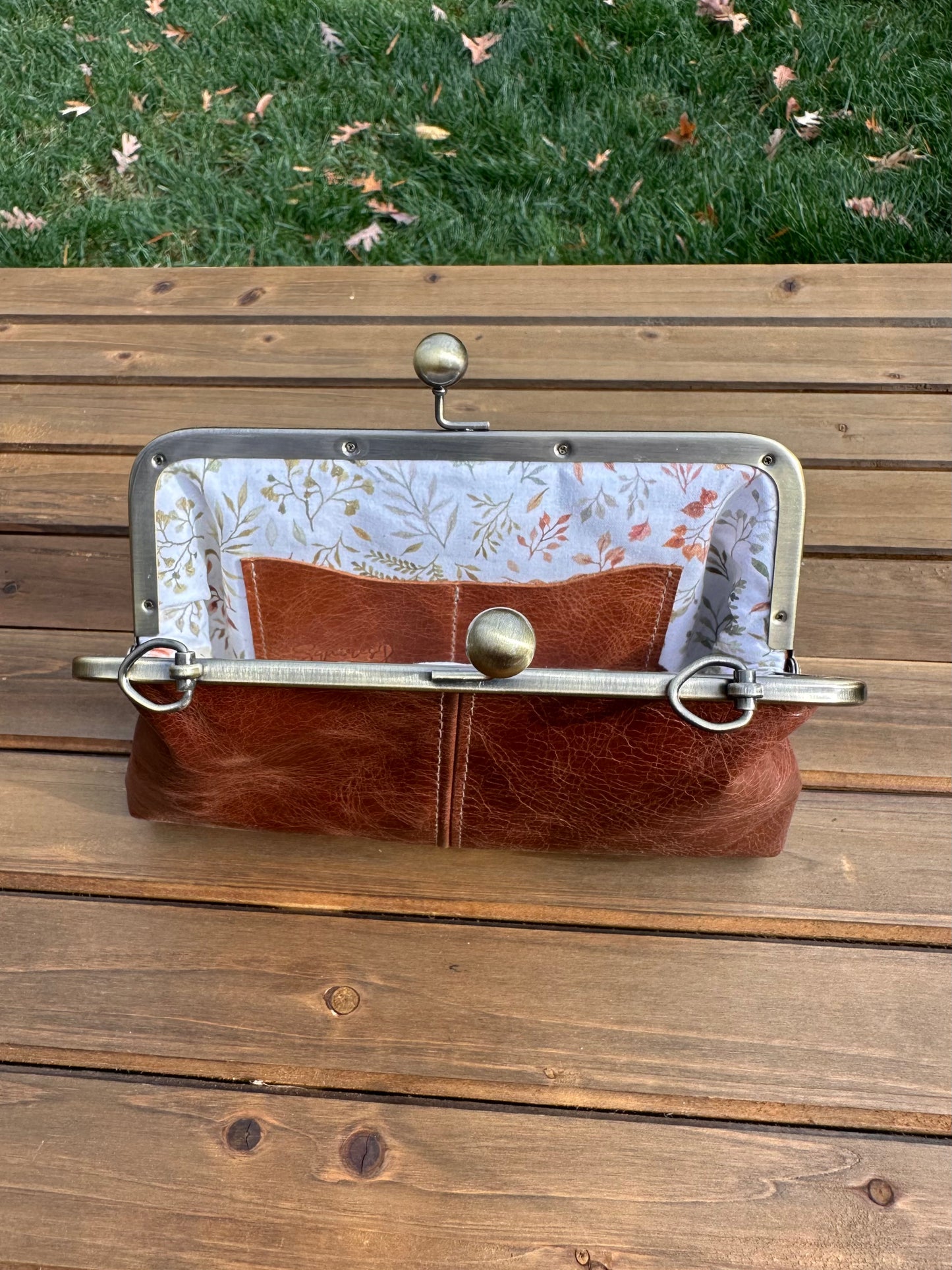 Interior of Brandy leather kiss lock purse with Ivory Floral lining. Includes 2 card slots and space for phone and essentials. Compact and functional design. Made in Maryland.
