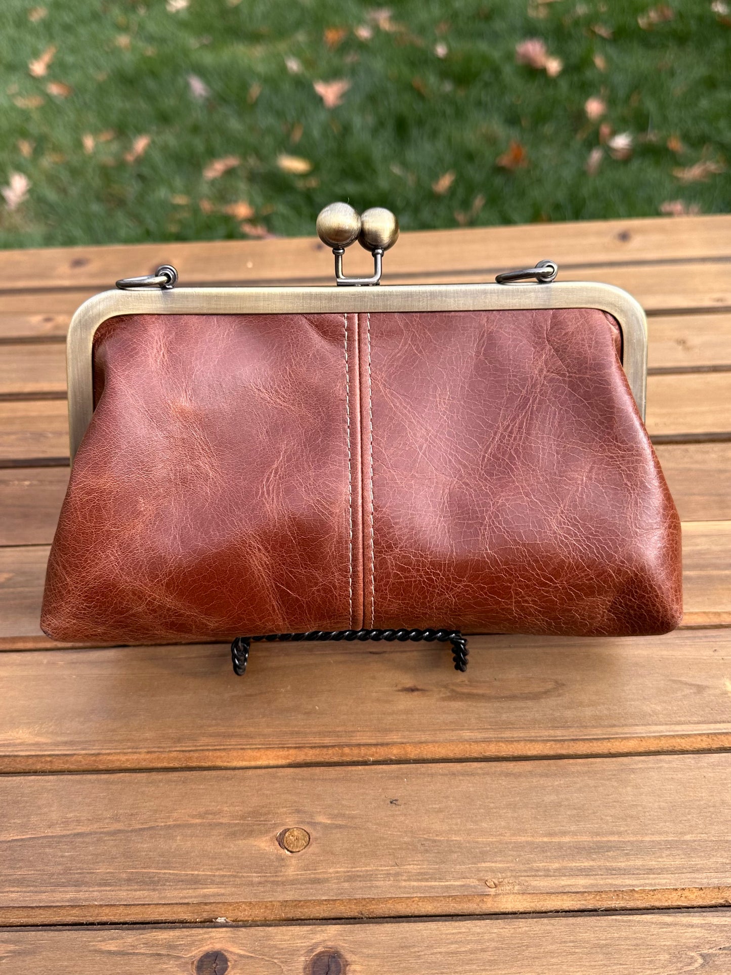 Brandy Leather kiss lock purse with bronze hardware. Wear as a clutch, crossbody, or shoulder bag. Holds phone, cards, and essentials. Made in Maryland.