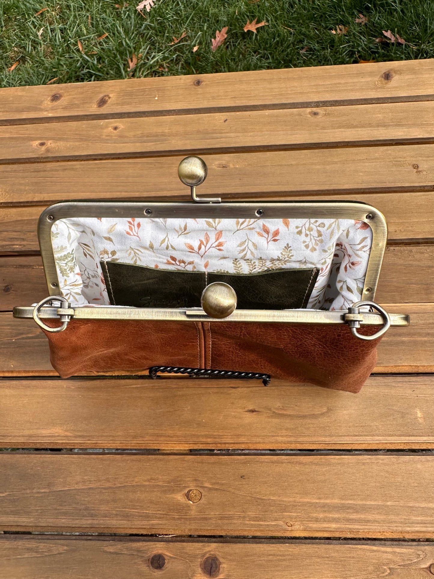 Interior of Brandy leather kiss lock purse with Ivory Floral lining. Includes 2 card slots and space for phone and essentials. Compact and functional design. Made in Maryland.