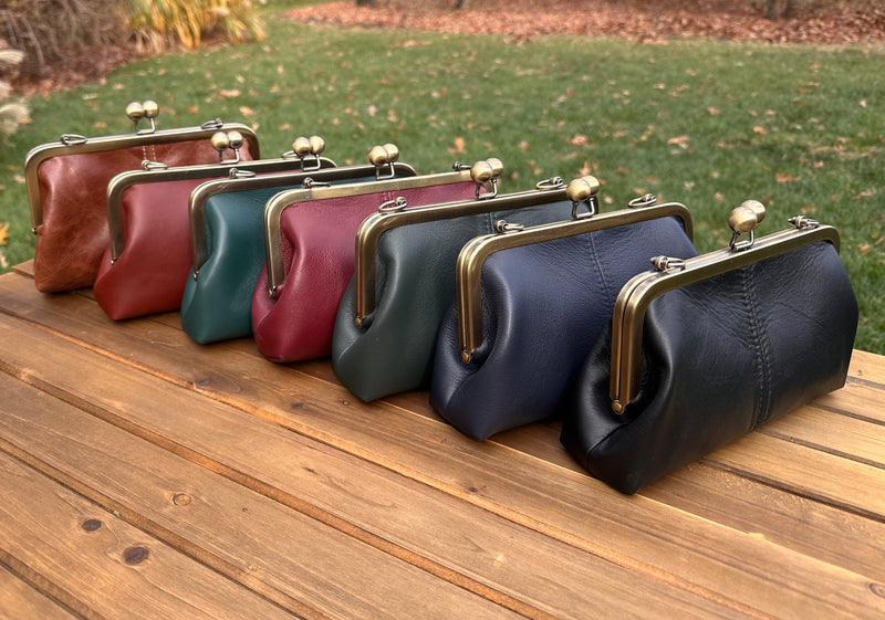 Collection of handcrafted leather kiss lock purses with bronze hardware and chain straps. Wear as clutch, shoulder, or crossbody. Made in Maryland.