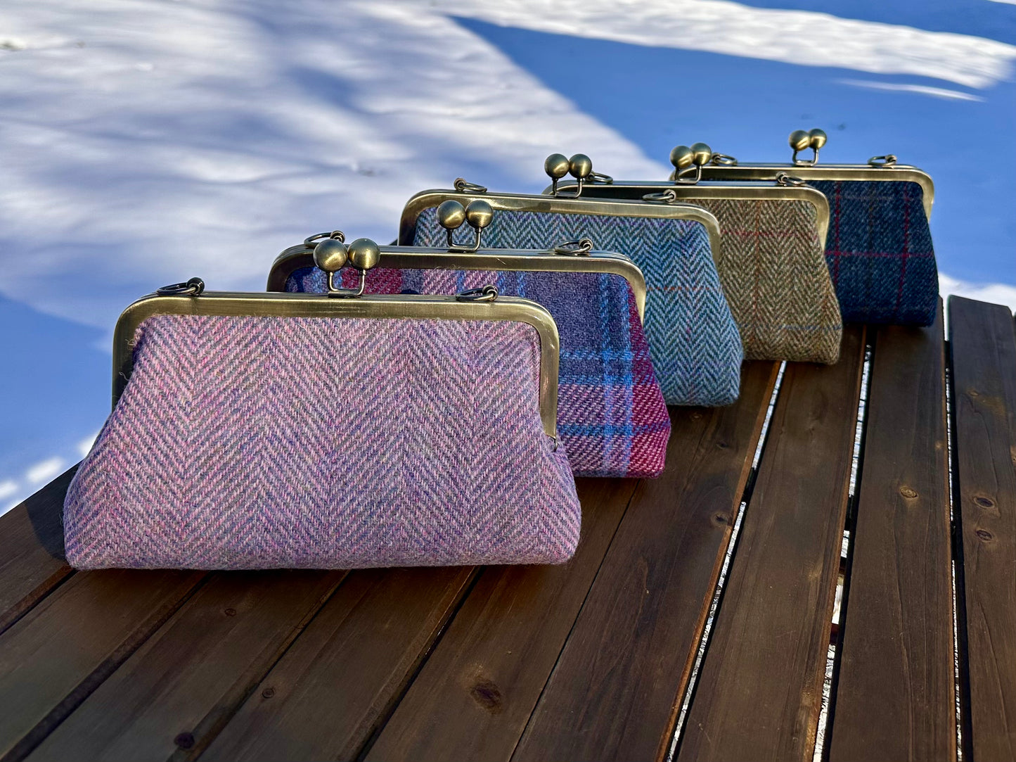 Collection of handcrafted Harris Tweed® kiss lock purses with bronze hardware. Classic clutch style with 2 card slots, fits a phone and small essentials. Wear as a clutch, shoulder bag, or crossbody. Made in Maryland, perfect for special occasions.