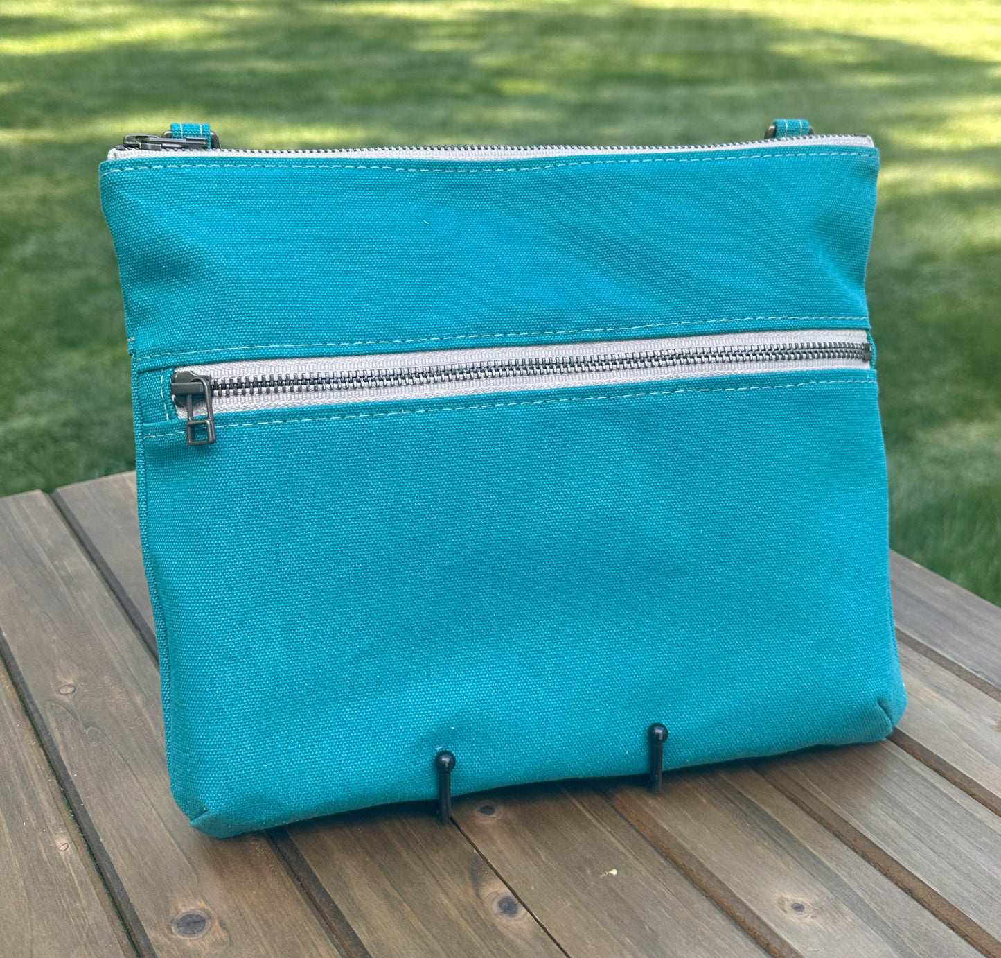 Front View Handcrafted Canvas Bayside Slim Crossbody Bag in Teal canvas with cotton canvas lining and adjustable Splenda vegetable-tanned leather strap. Lightweight and perfect for everyday wear.