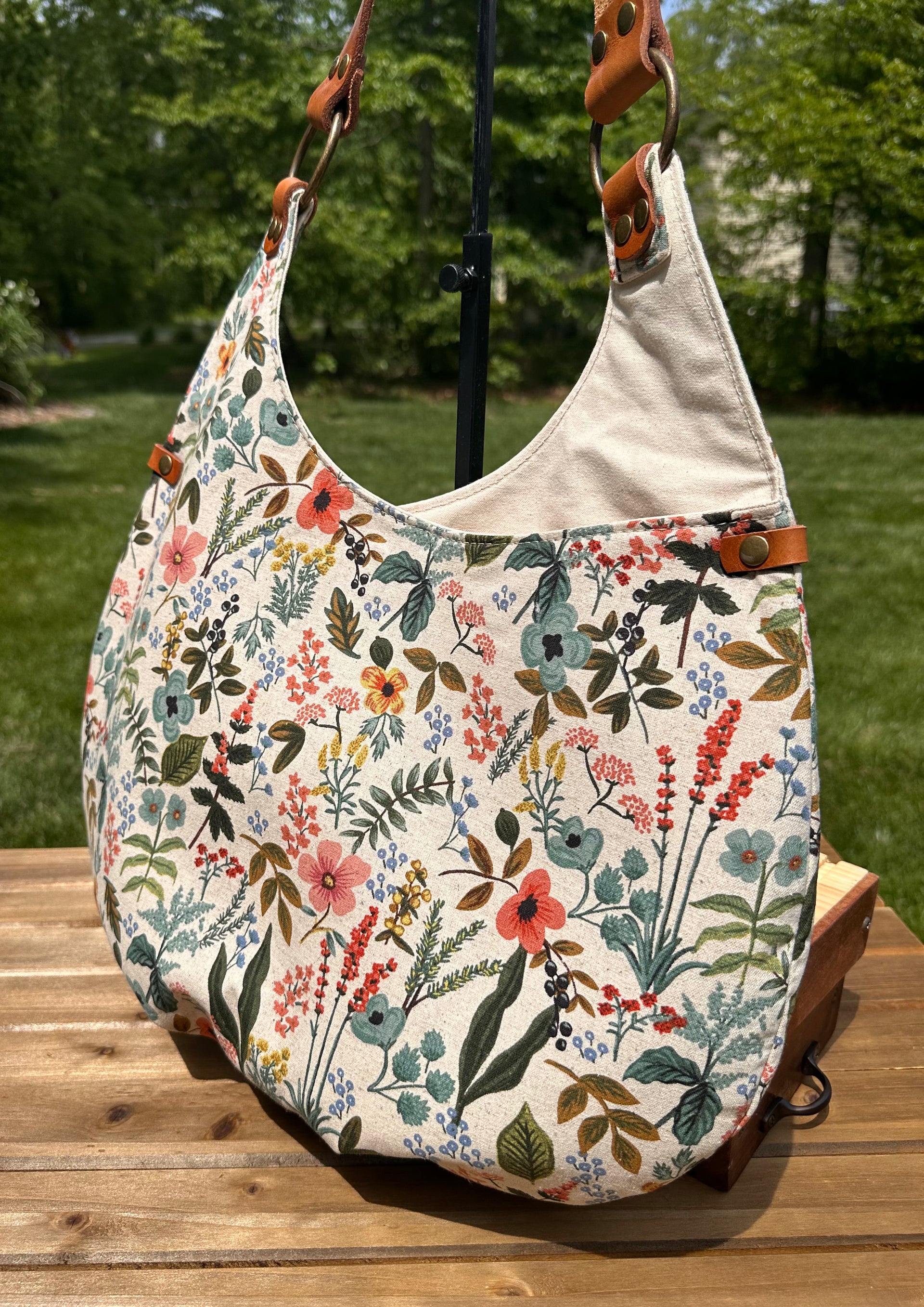 Close up of the Compass Rose Shoulder bag showing the Rifle Paper Co. Herb Garden Natural Canvas with Cognac Leather.