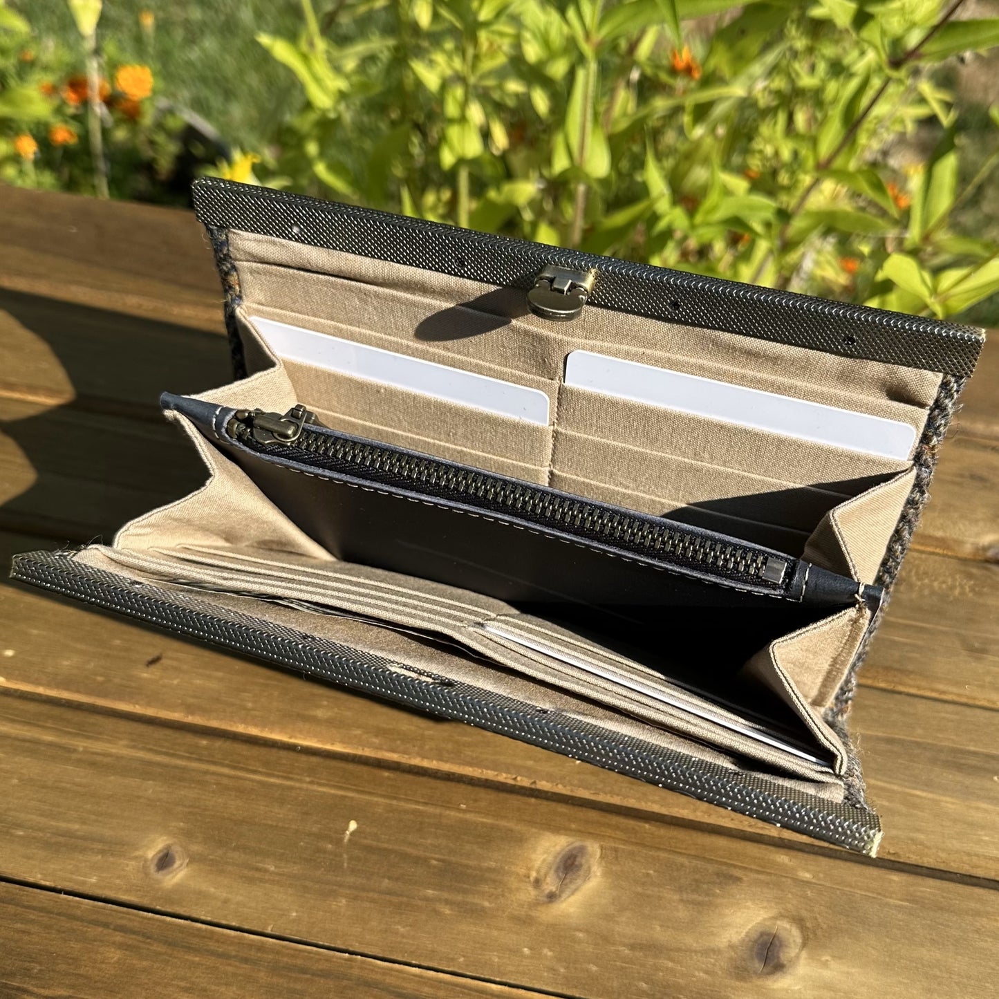 Interior view of the open Harris Tweed® Large Rock Hall Wallet, highlighting the organization features: card slots, cash slip pocket, and leather zipper coin pouch.