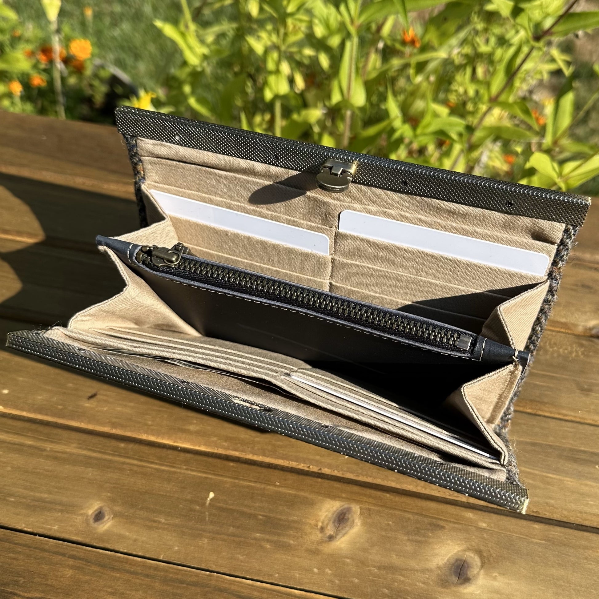 Interior view of the open Harris Tweed® Large Rock Hall Wallet, highlighting the organization features: card slots, cash slip pocket, and leather zipper coin pouch.