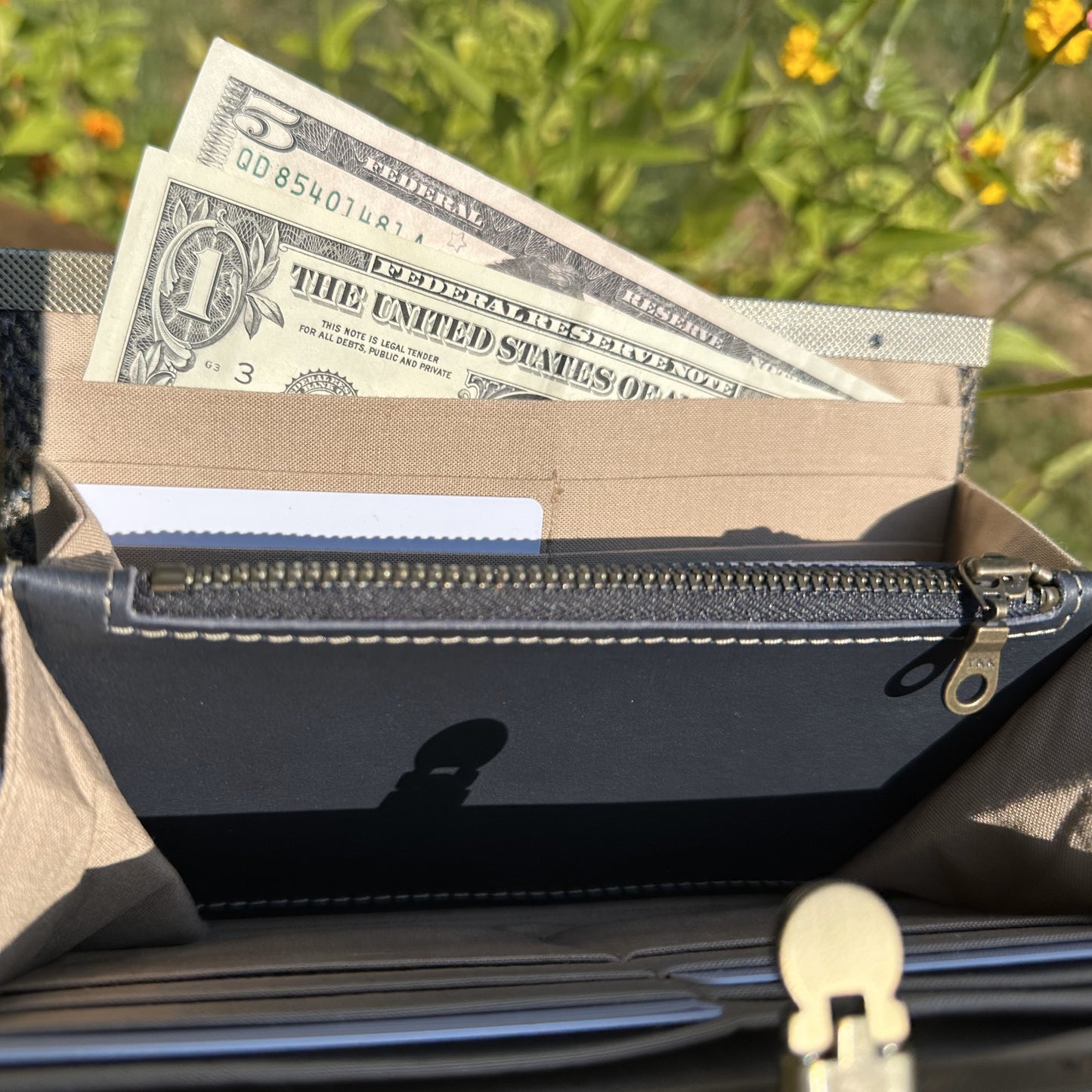 Interior view of the open Harris Tweed® Large Rock Hall Wallet, highlighting the organization features: card slots, cash slip pocket, and leather zipper coin pouch.