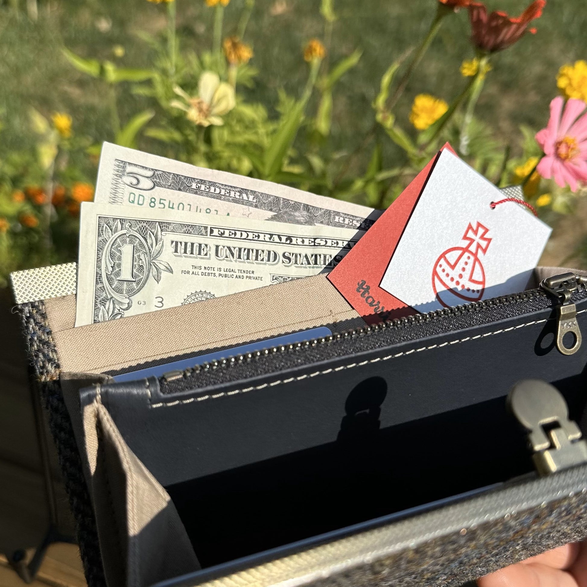 Interior view of the open Harris Tweed® Large Rock Hall Wallet, highlighting the organization features: card slots, cash slip pocket, and leather zipper coin pouch.
