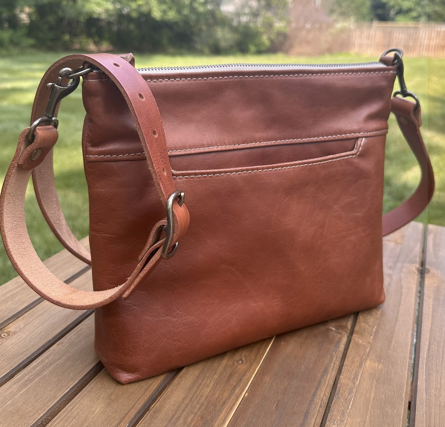 Front view of a handcrafted Leather Bayside Crossbody bag in Sienna Horween leather, showcasing its rich, warm color, natural grain, solid brass hardware, and full metal zipper. Designed and made in Maryland.