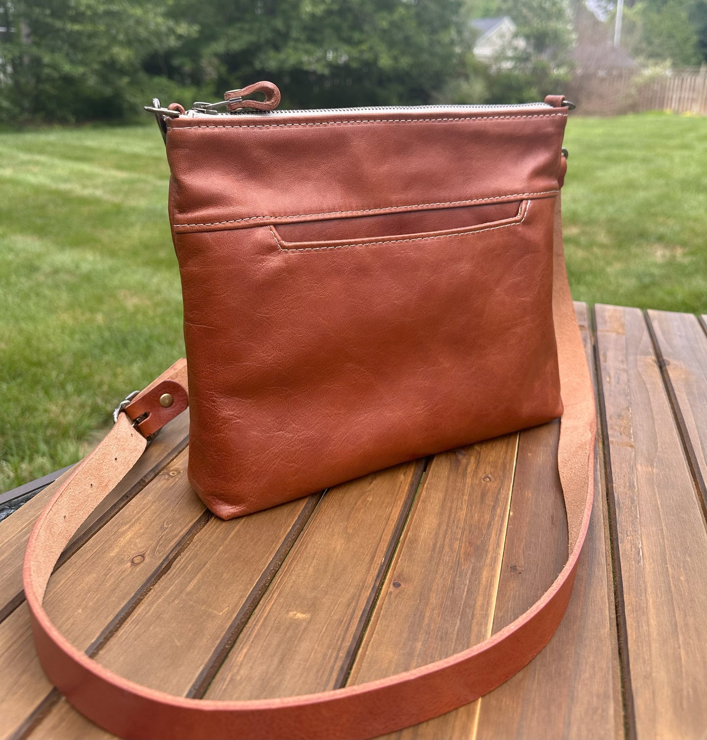 Front view of a handcrafted Leather Bayside Crossbody bag in Sienna Horween leather, showcasing its rich, warm color, natural grain, solid brass hardware, and full metal zipper. Designed and made in Maryland.