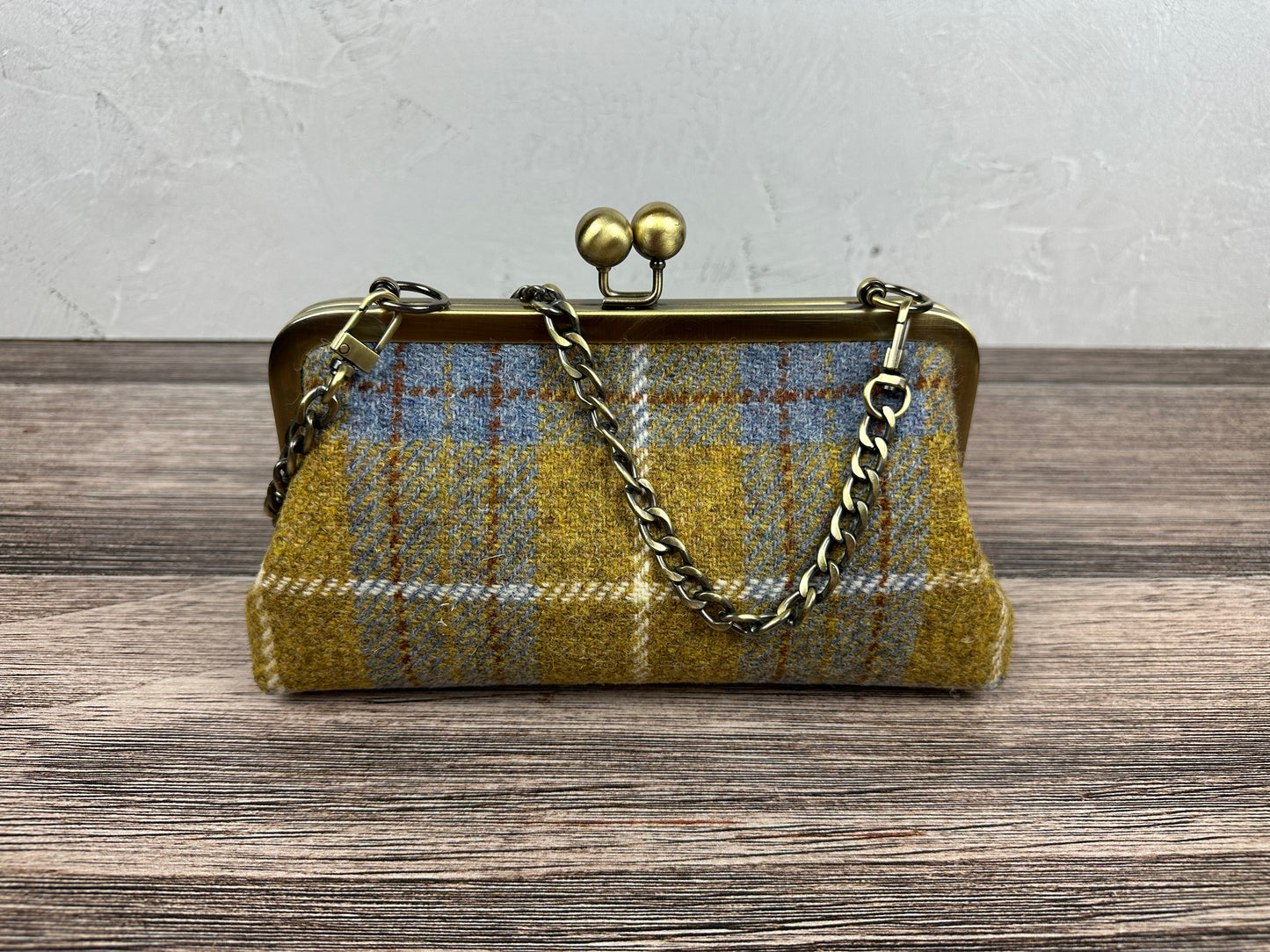 Harris Tweed® kiss lock purse in Yellow and Blue Plaid with bronze hardware. Wear as a clutch, attach chain for shoulder or crossbody wear. Holds phone, cards, and small items. Timeless design handcrafted in Maryland.