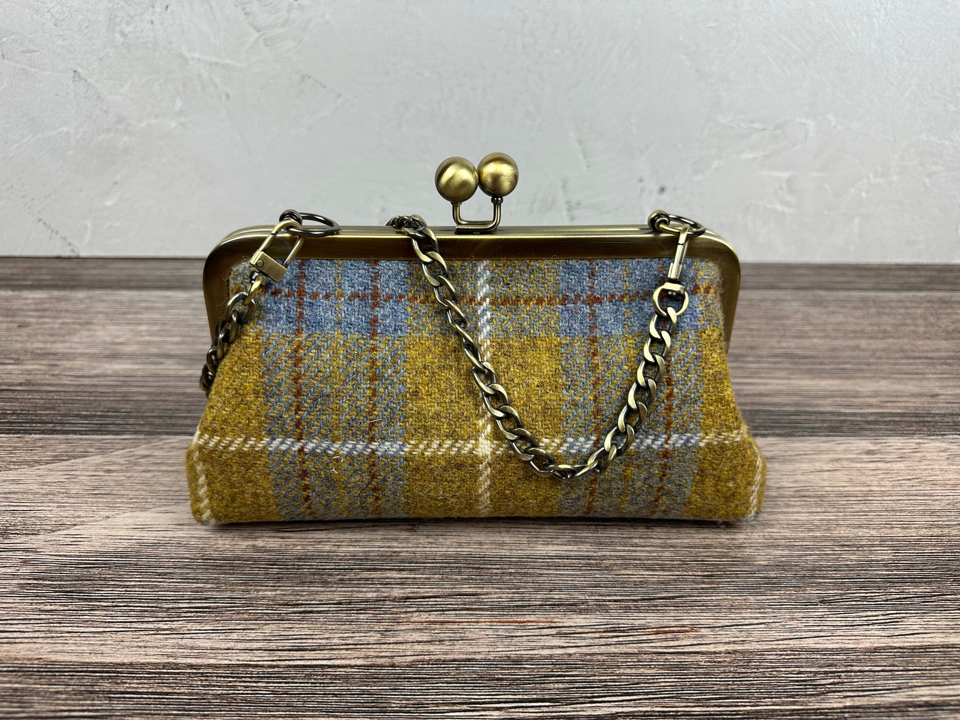 Harris Tweed® kiss lock purse in Yellow and Blue Plaid with bronze hardware. Wear as a clutch, attach chain for shoulder or crossbody wear. Holds phone, cards, and small items. Timeless design handcrafted in Maryland.