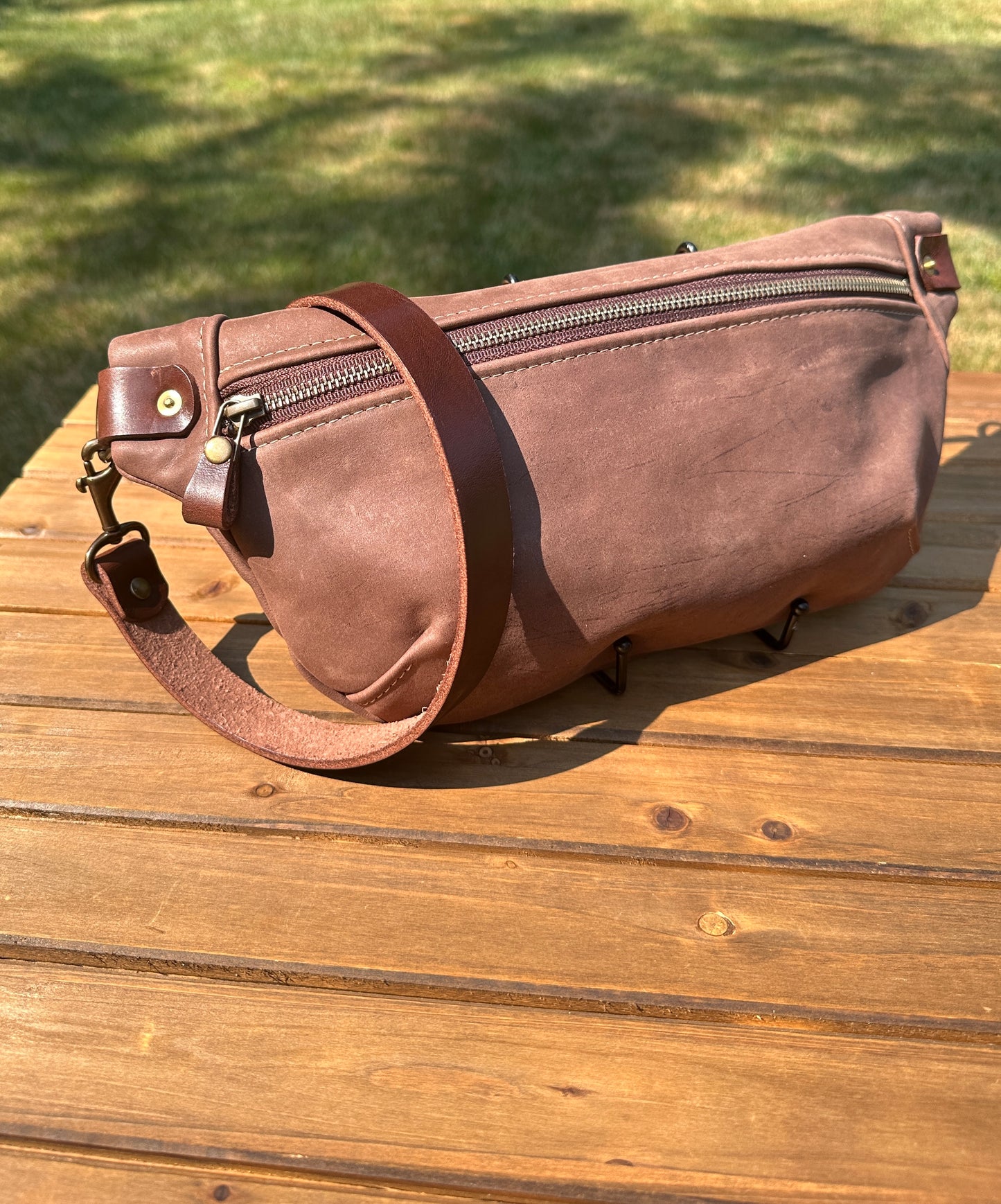 Front view of Leather Spinnaker Sling bag in Vintage Dark Brown Leather with bronze hardware, linen interior, and front zipper. Unisex slim crossbody sling handmade in Maryland.