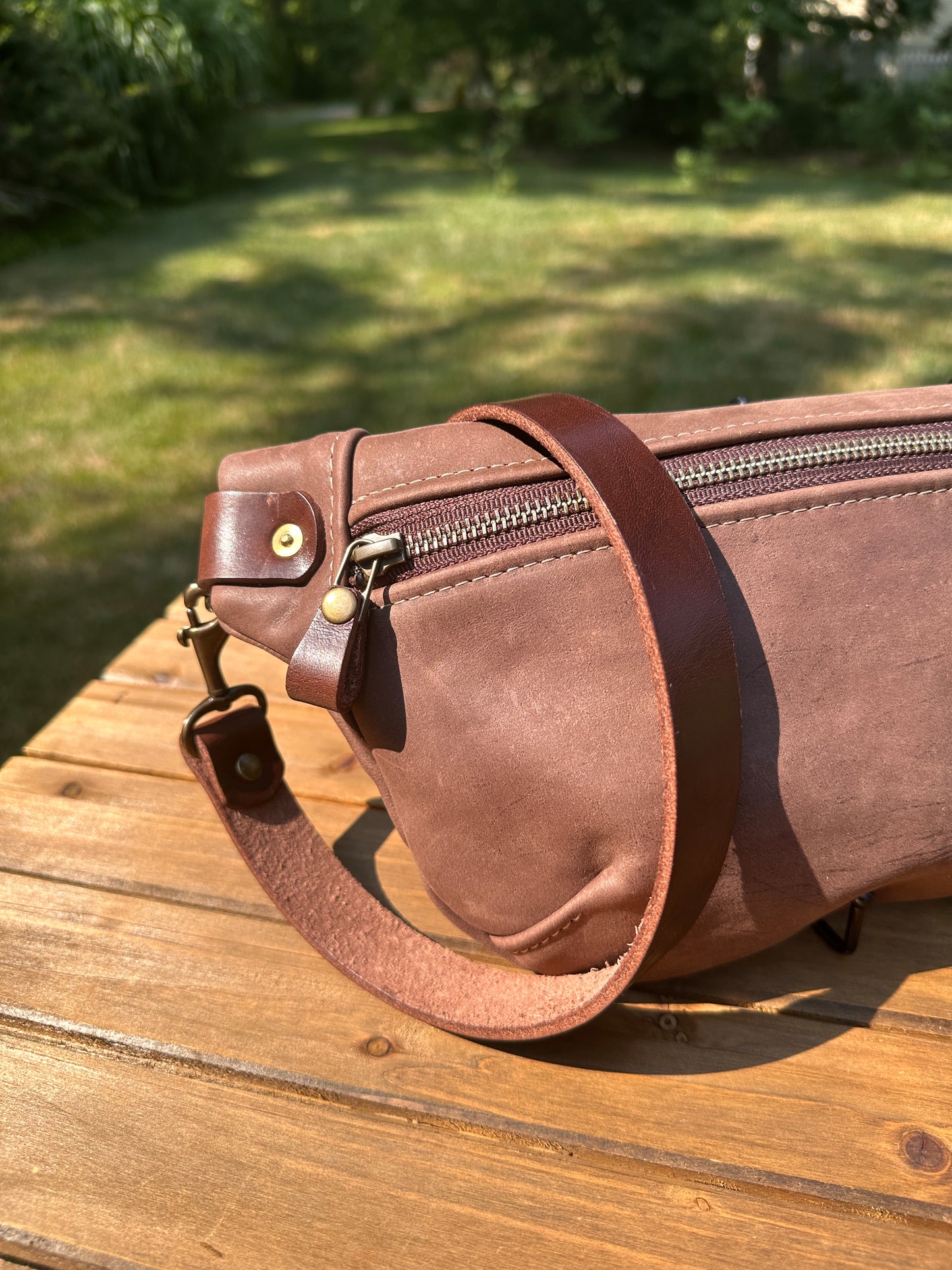 Close-up detail of the front zipper and grain texture on the Leather Spinnaker Sling in Vintage Dark Brown Leather, with solid brass hardware and full-grain leather.