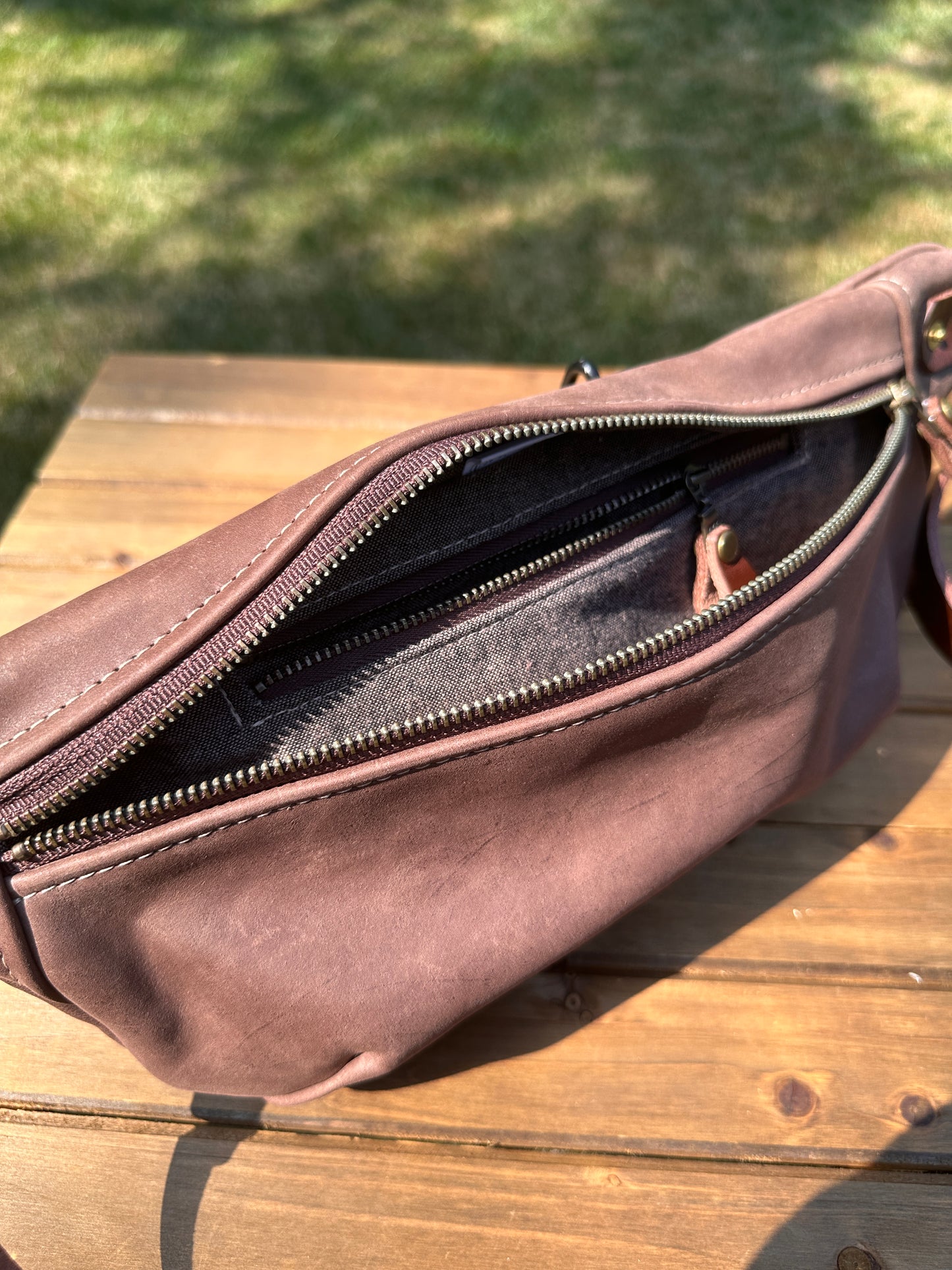 Interior view of Leather Spinnaker Sling bag in Vintage Dark Brown Leather with linen lining and interior zipper pocket. Slim and practical leather sling bag handcrafted in Maryland.
