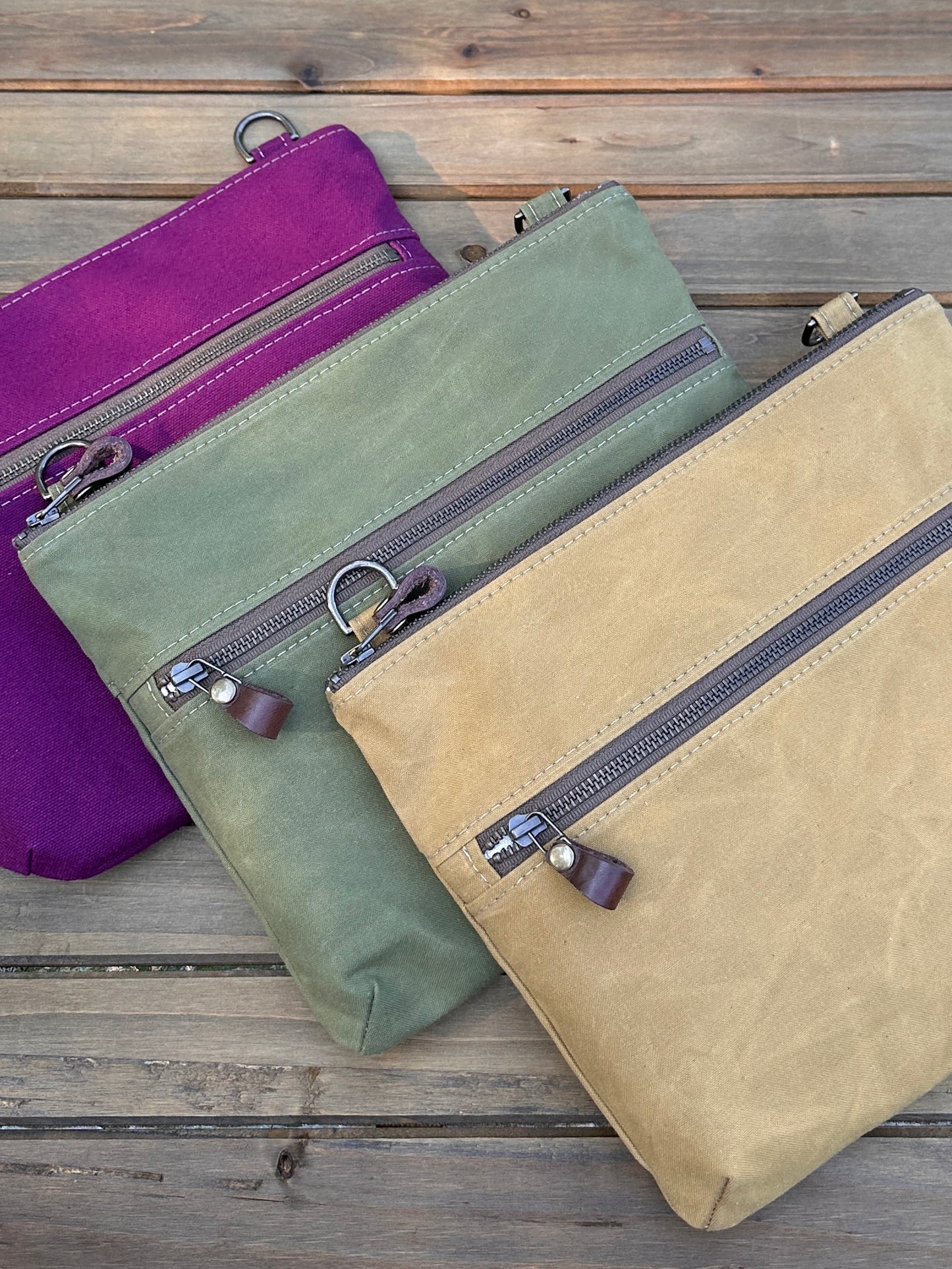 Collection of handcrafted Canvas Bayside Slim Crossbody Bags in waxed canvas, and solid canvas styles, with full canvas lining and adjustable vegetable-tanned leather straps.