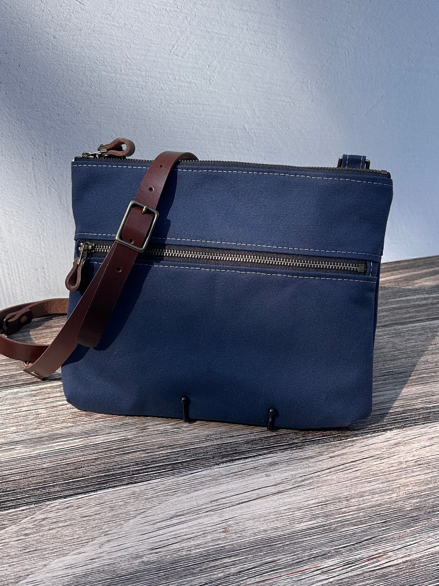 Front View Handcrafted Canvas Bayside Slim Crossbody Bag in Navy 18oz canvas with cotton canvas lining and adjustable Splenda vegetable-tanned leather strap. Lightweight and perfect for everyday wear.