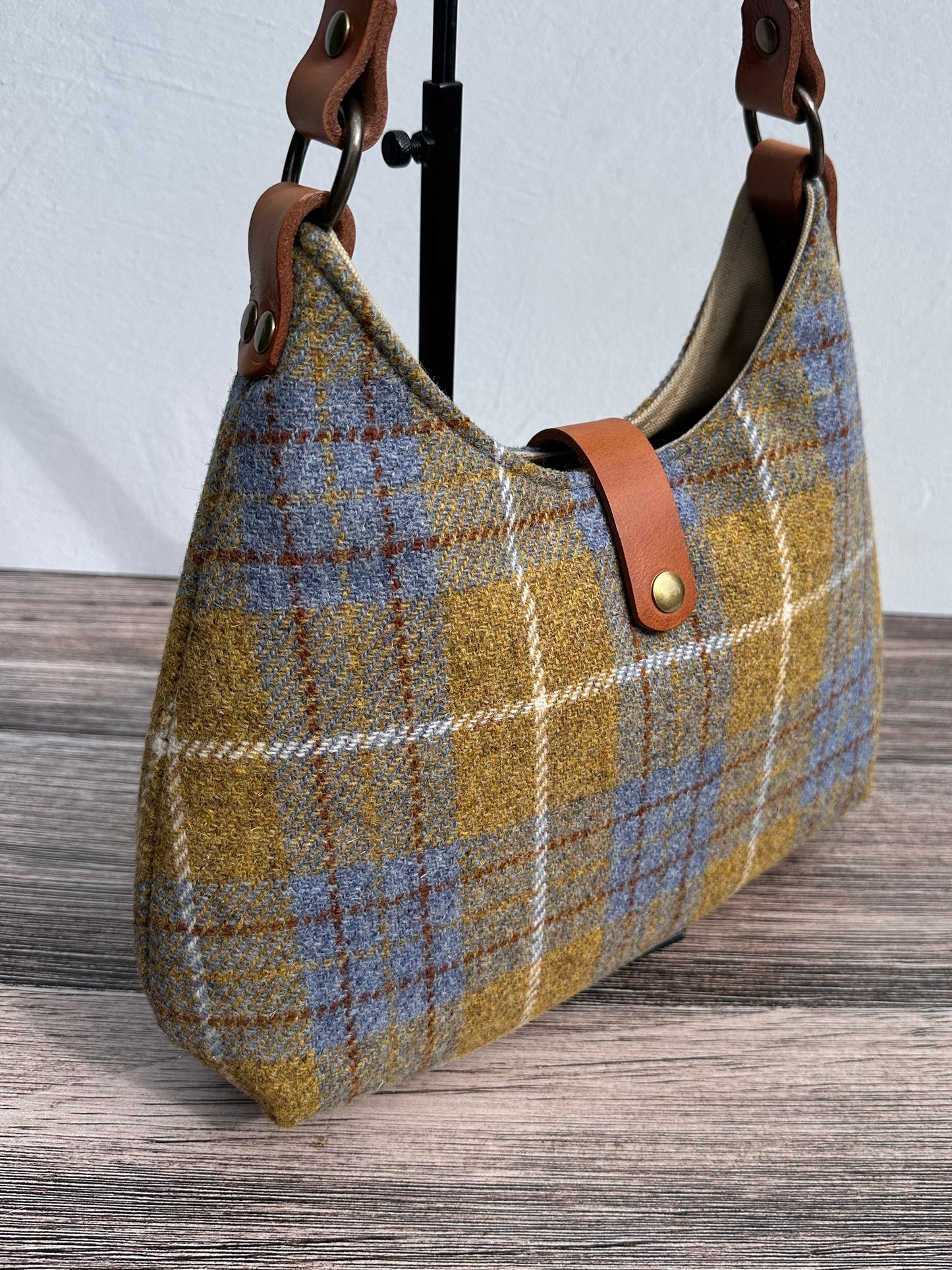Close up view of Yellow and Blue Plaid Harris Tweed® Rhode River Shoulder Bags, Cognac Leather with Antique Brass Hardware. Handcrafted in Maryland
