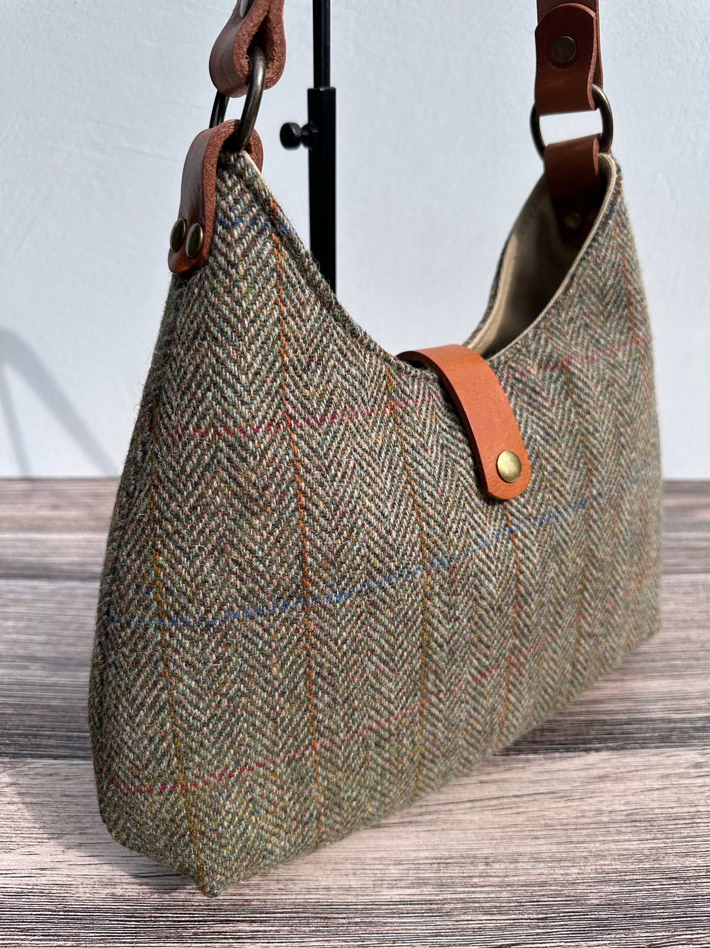 up close view Green Mix Herringbone Harris Tweed® Rhode River Shoulder Bags, Cognac Leather with Antique Brass Hardware. Handcrafted in Maryland
