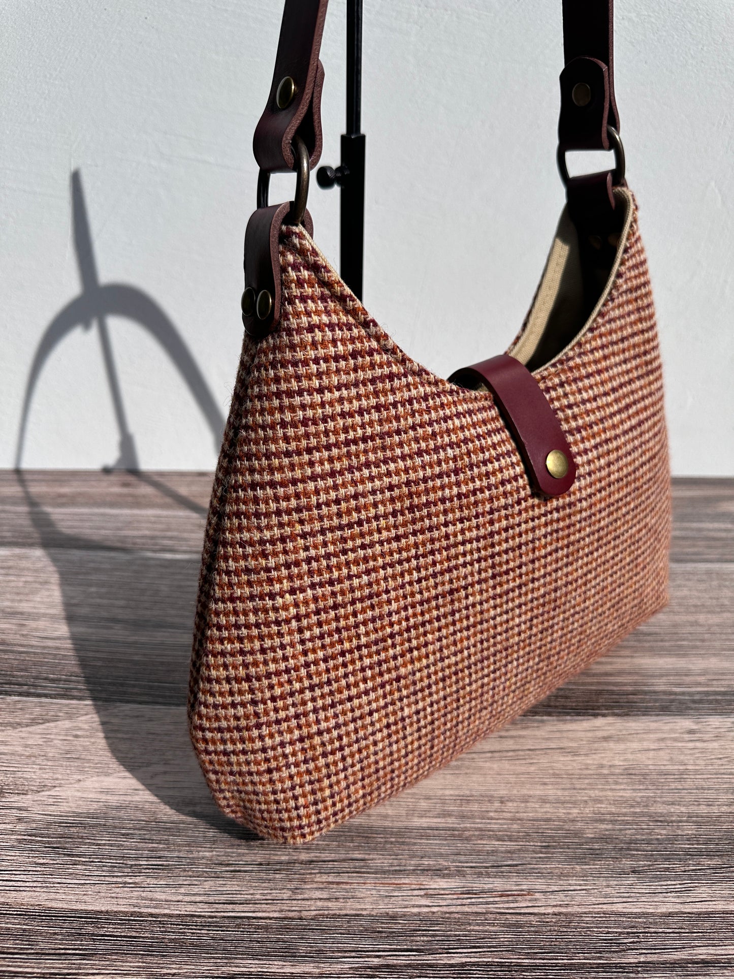 Close up view Fawn & Amber Harris Tweed® Rhode River Shoulder Bags, Bordeaux Leather with Antique Brass Hardware. Handcrafted in Maryland
