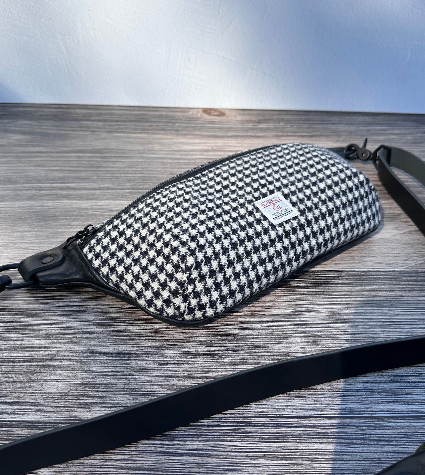 Minimalist sling bag handcrafted with Black and White Houndstooth Harris Tweed® and Horween Black Leather, finished with Matte Black hardware.