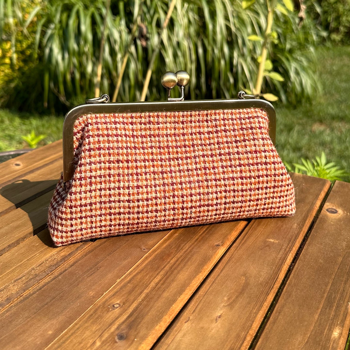 Harris Tweed® kiss lock purse in Fawn Burgundy with bronze hardware. Wear as a clutch, attach chain for shoulder or crossbody wear. Holds phone, cards, and small items. Timeless design handcrafted in Maryland.