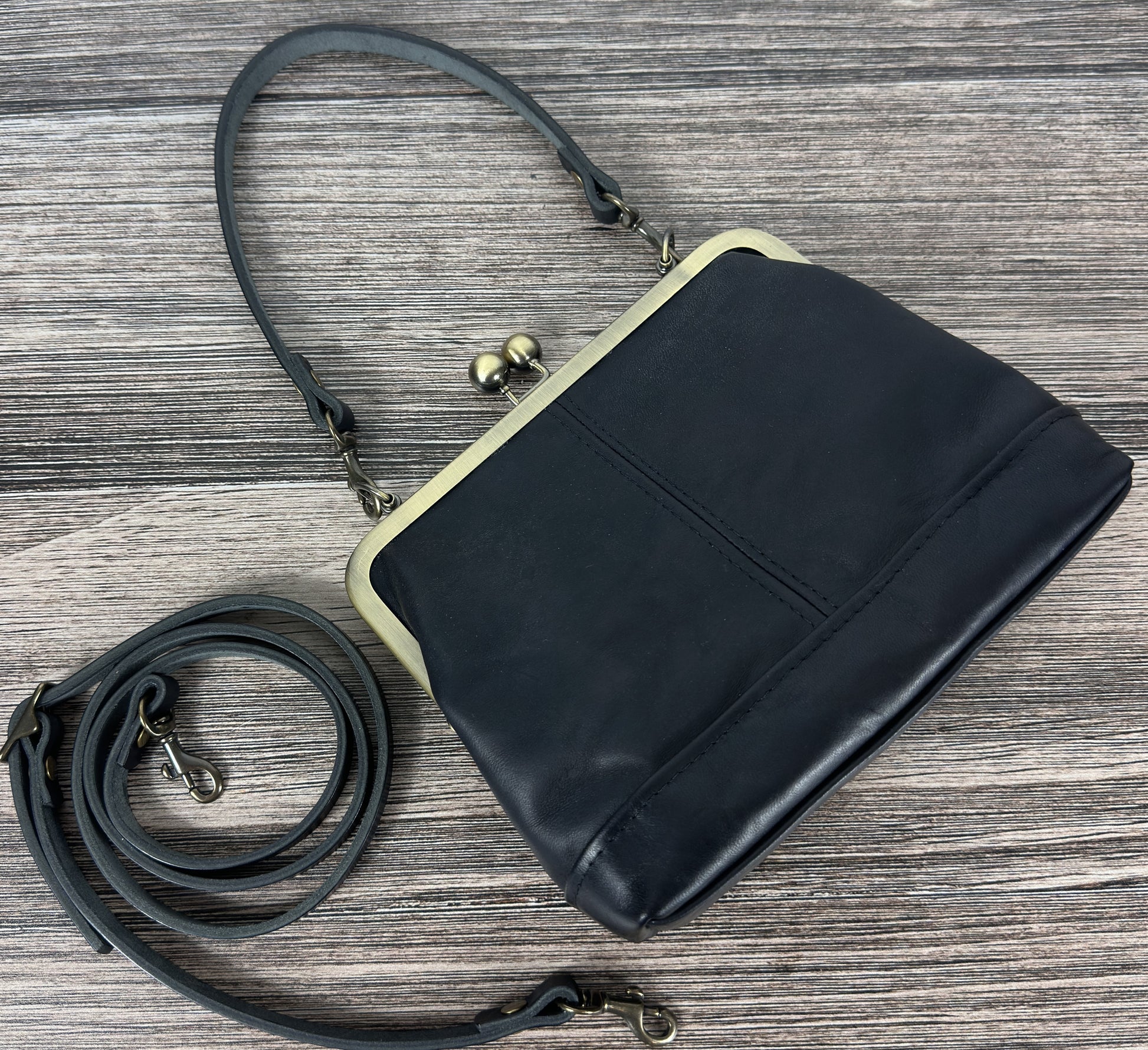 Handcrafted full-grain leather Princess Anne Kiss Lock handbag featuring a vintage-style frame and convertible straps.