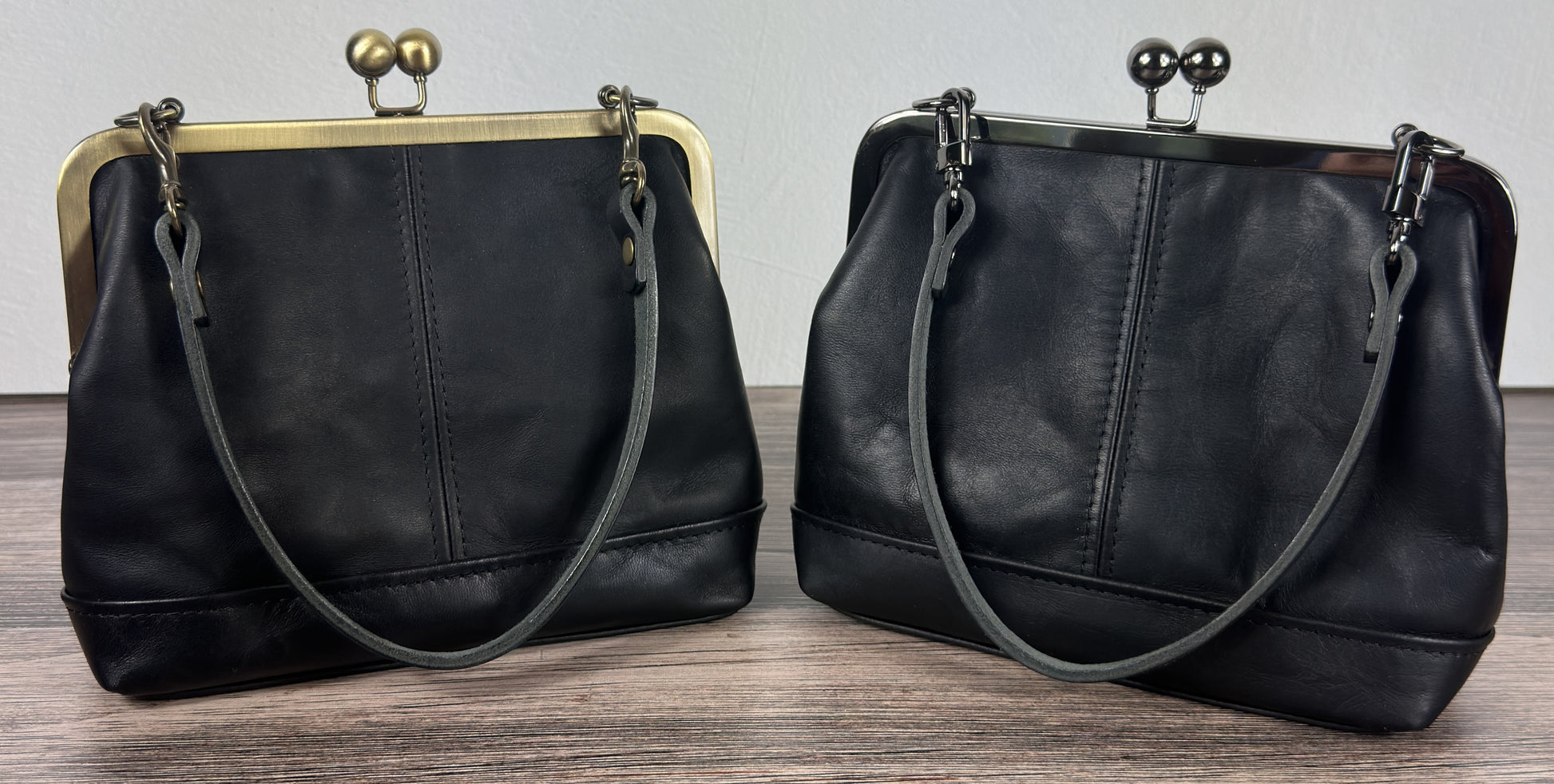 Two Handcrafted full-grain leather Princess Anne Kiss Lock handbag featuring a vintage-style frame and convertible straps.