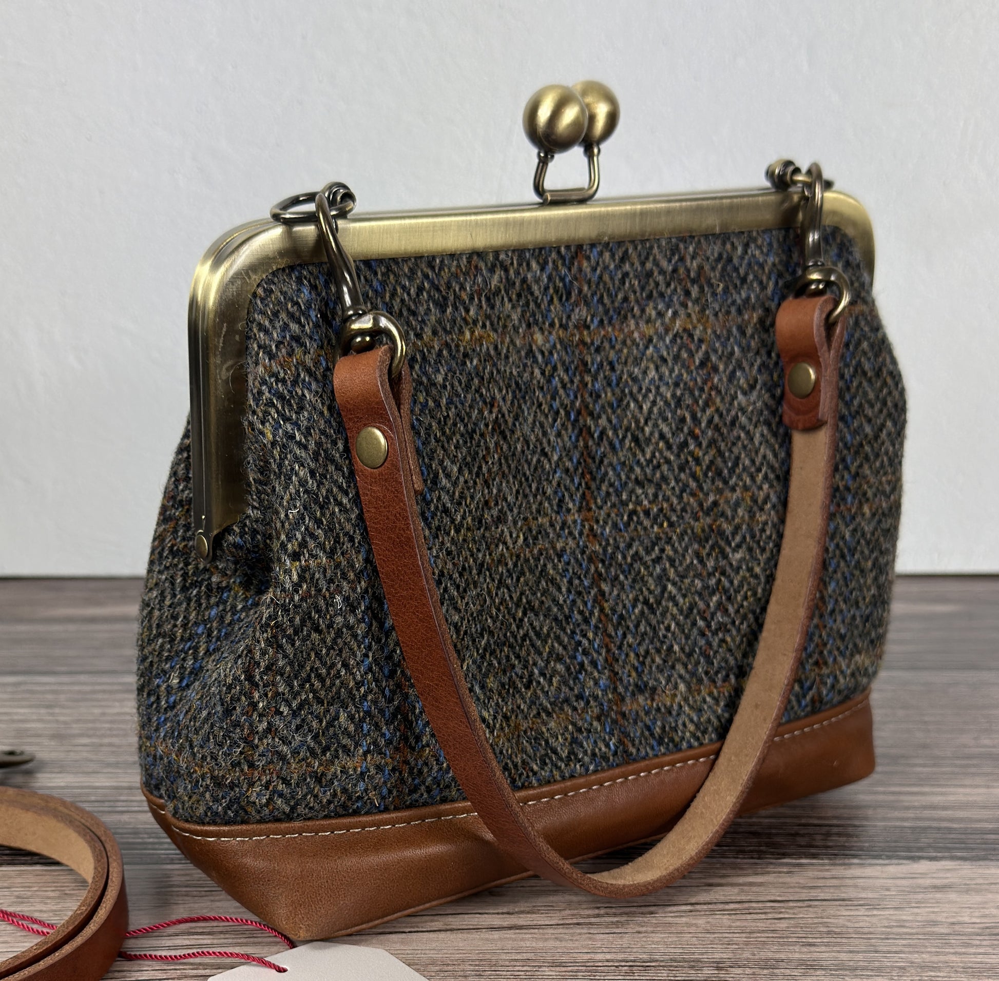 Harris Tweed® Princess Anne Kiss Lock Purse in Green Blue Herringbone with leather base, handbag strap, and crossbody strap — handcrafted in Maryland.
