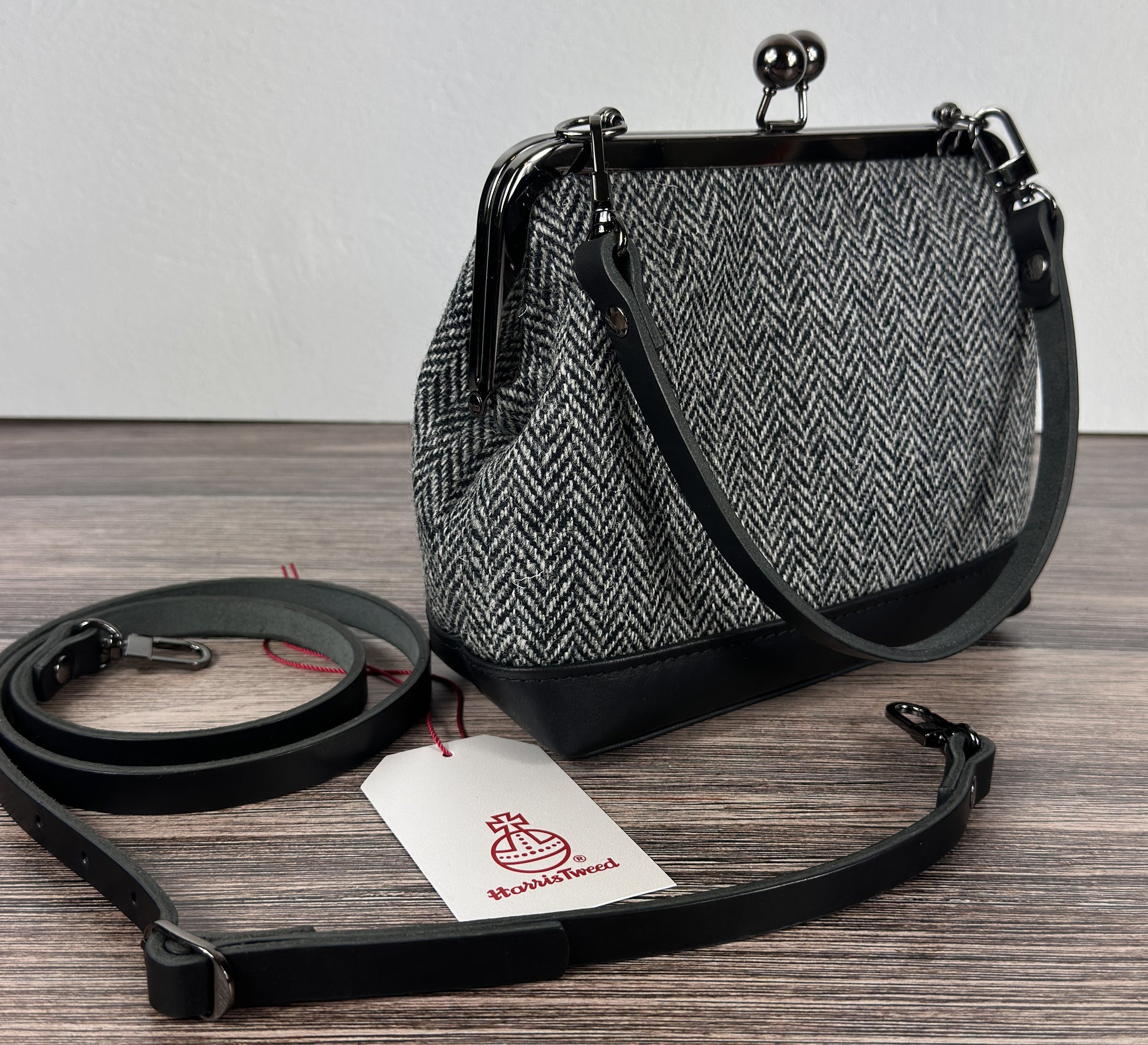 Harris Tweed® Princess Anne Kiss Lock Purse in Black and White Herringbone with leather base, handbag strap, and crossbody strap — handcrafted in Maryland.