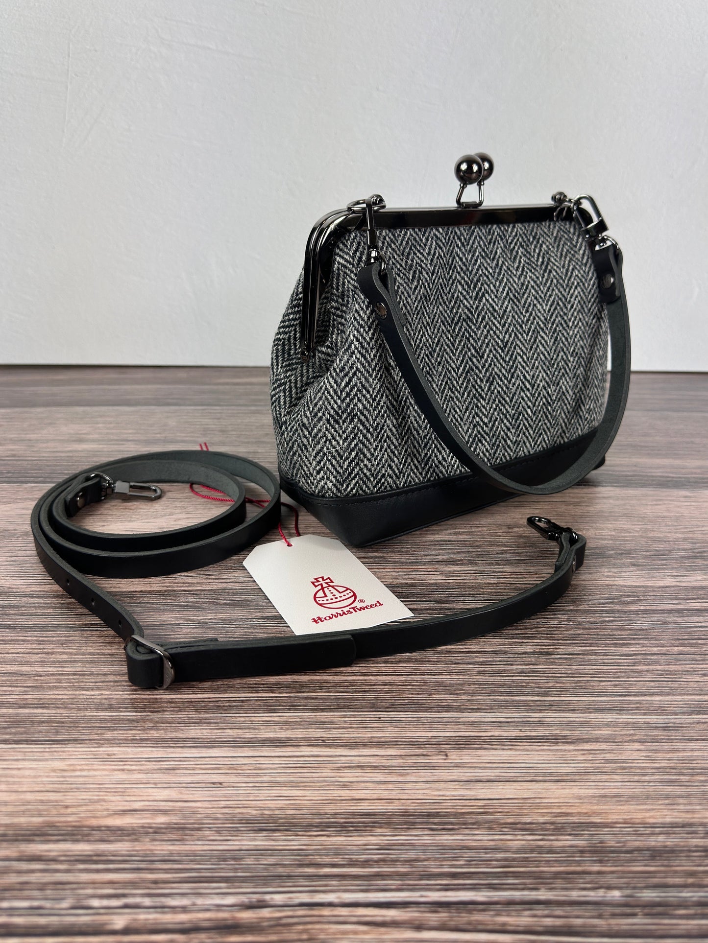 Harris Tweed® Princess Anne Kiss Lock Purse in Black and White Herringbone with leather base, handbag strap, and crossbody strap — handcrafted in Maryland.