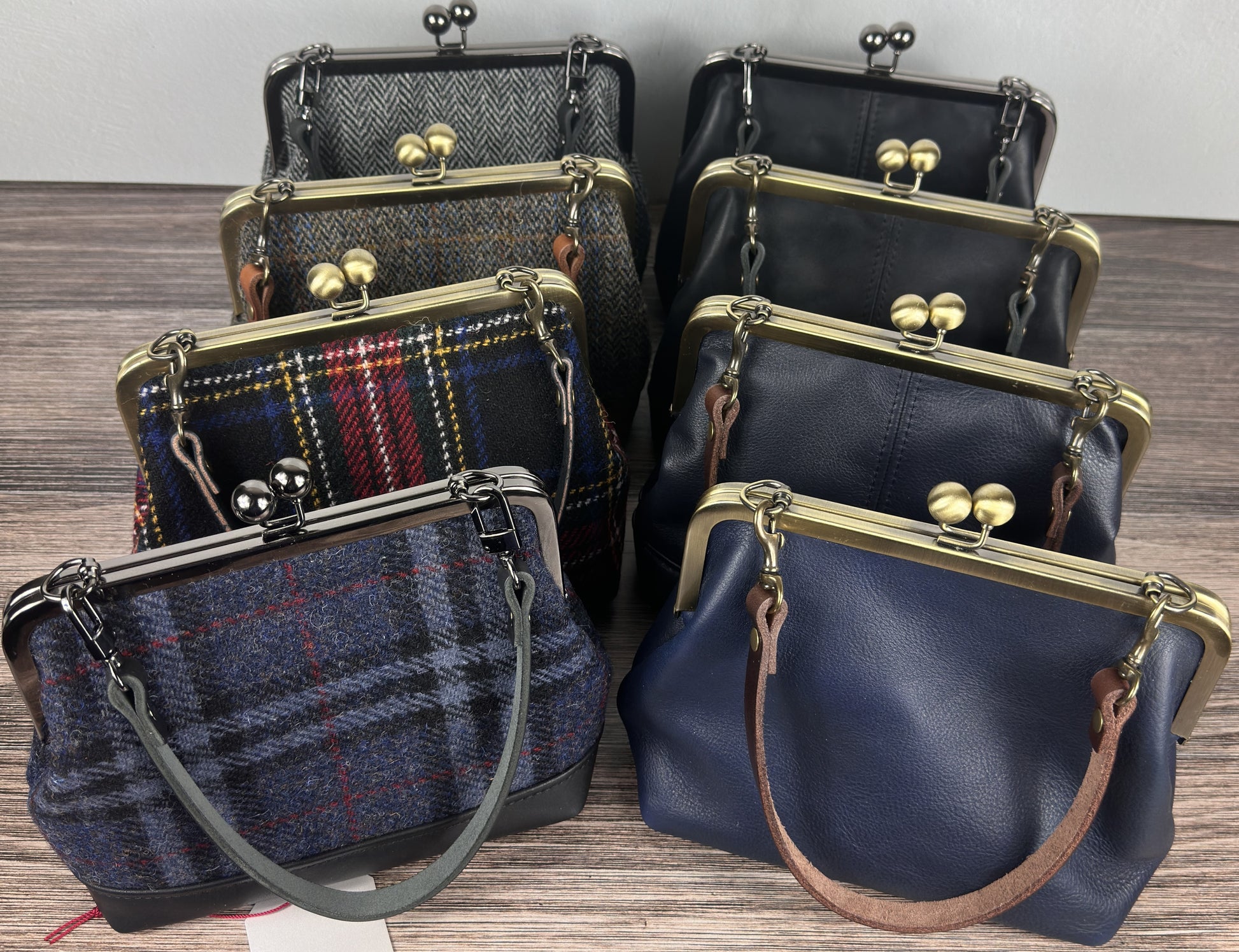 Collection of Harris Tweed® Princess Anne Kiss Lock Purses with leather bases, showcasing multiple tweed patterns and handcrafted detailing.