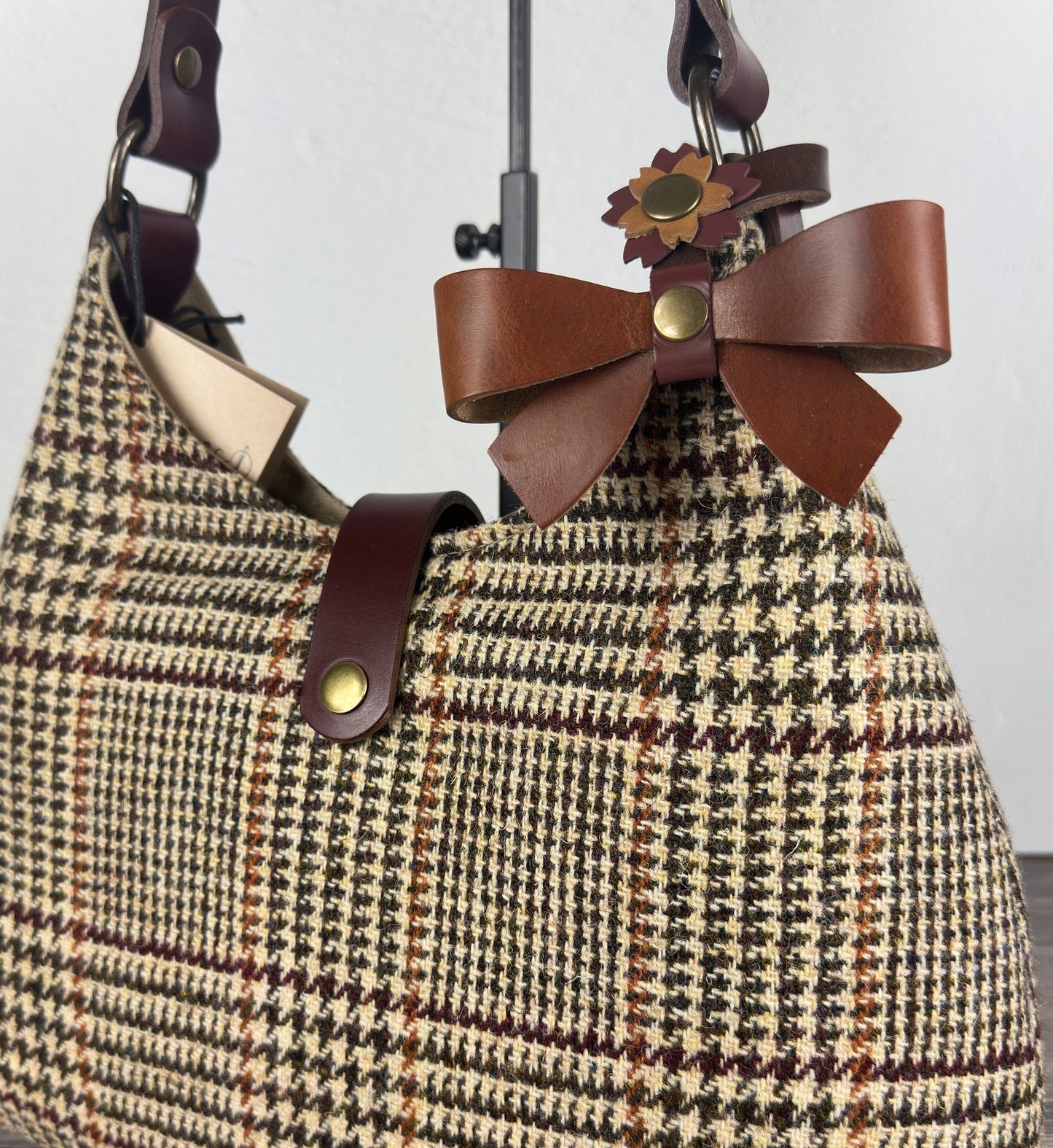 Leather bow bag charm clipped to Harris Tweed Rhode River Shoulder bag – handcrafted purse accessory cut by hand.