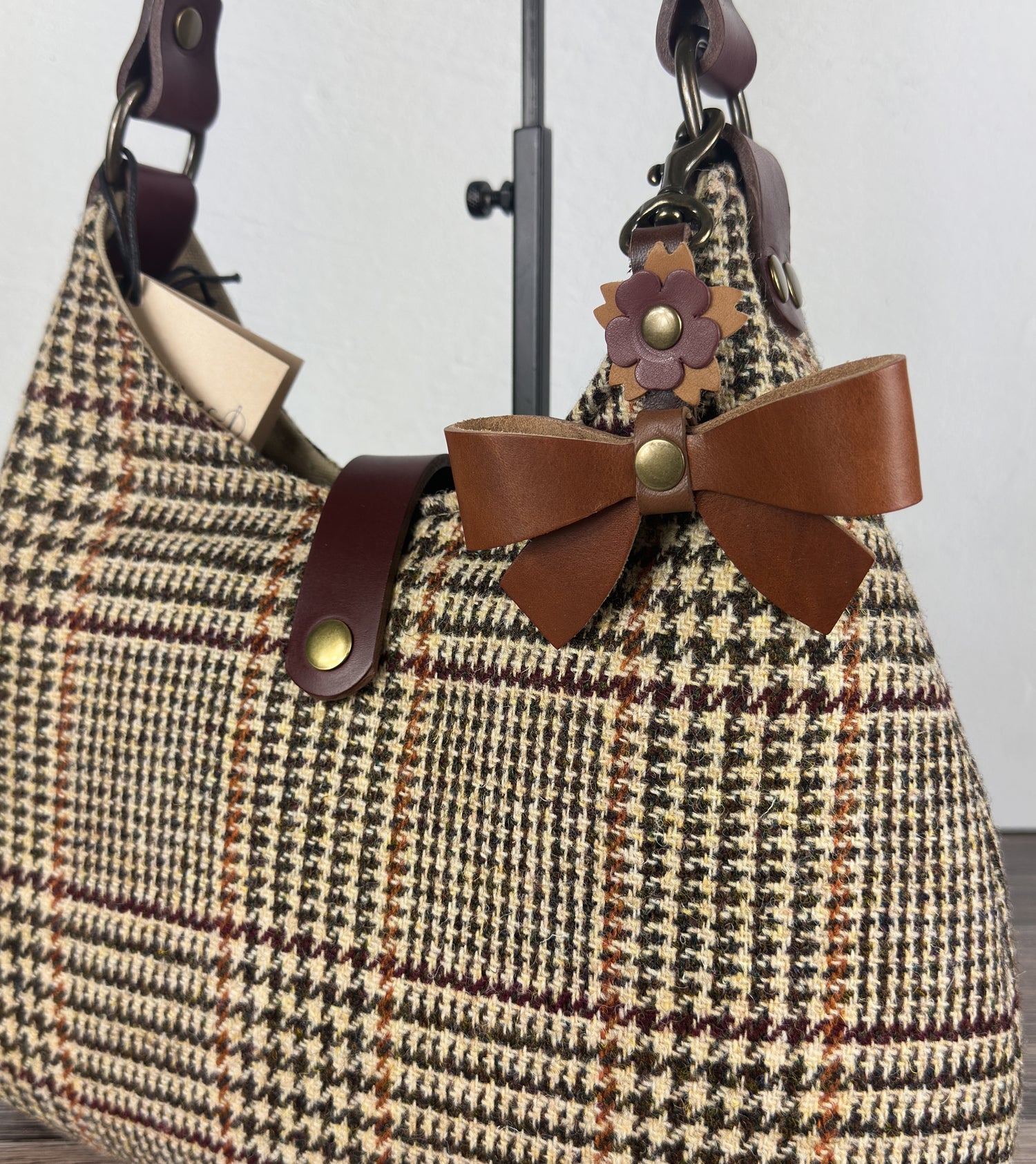 Leather bow bag charm clipped to Harris Tweed Rhode River Shoulder bag – handcrafted purse accessory cut by hand.