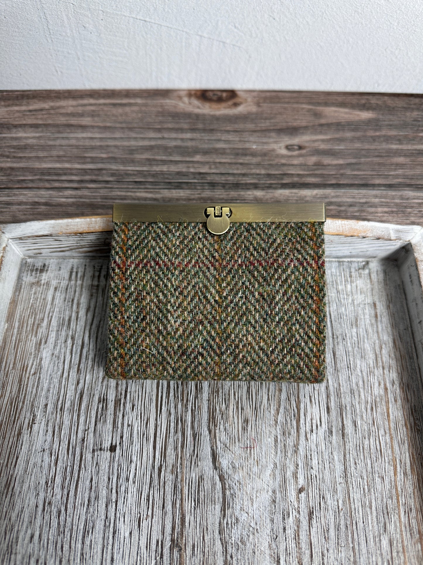 Closed Mini Harris Tweed® Rock Hall Wallet in Green Mix Herringbone, featuring Antique Brass flip-lock closure.