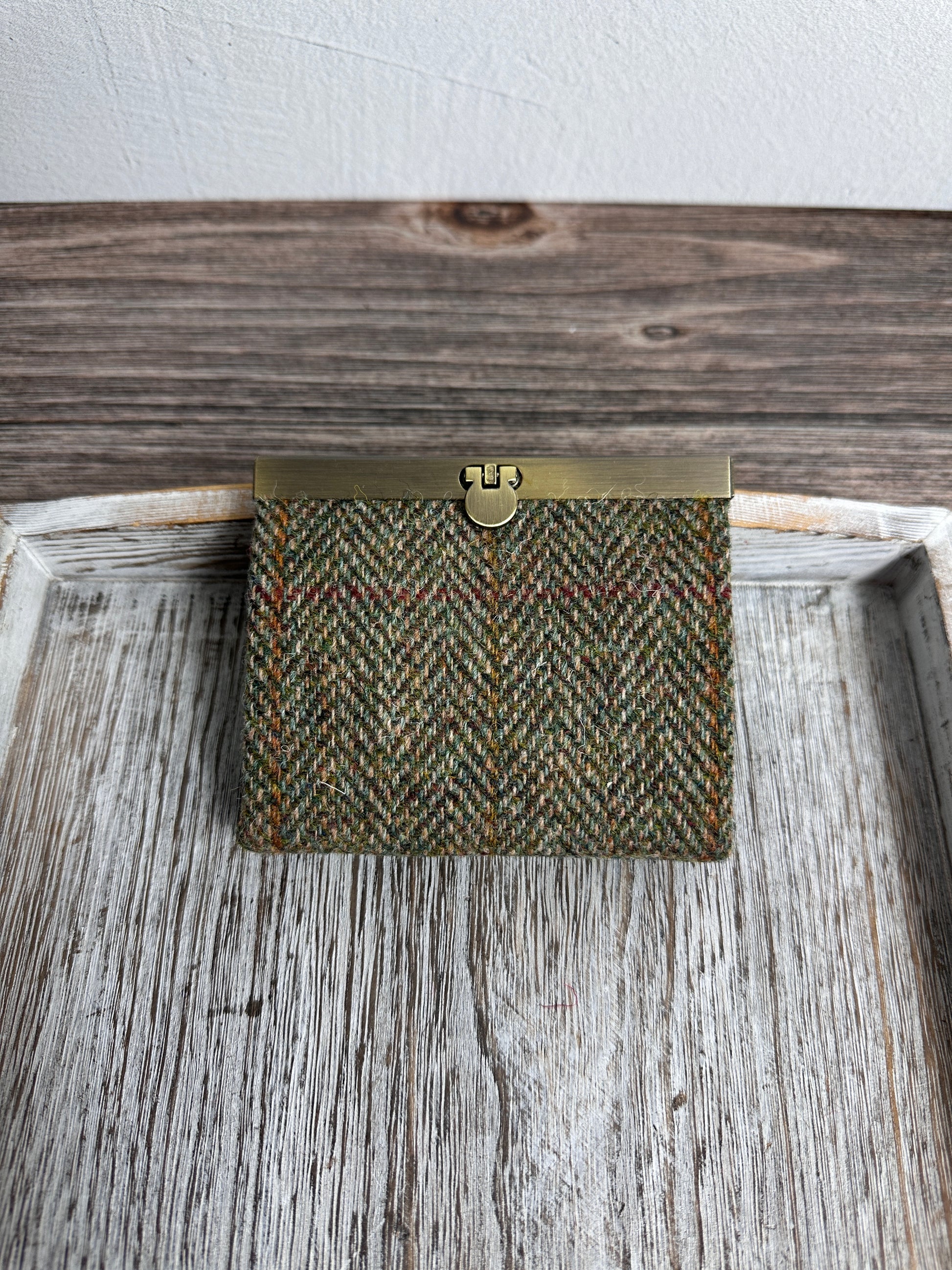 Closed Mini Harris Tweed® Rock Hall Wallet in Green Mix Herringbone, featuring Antique Brass flip-lock closure.