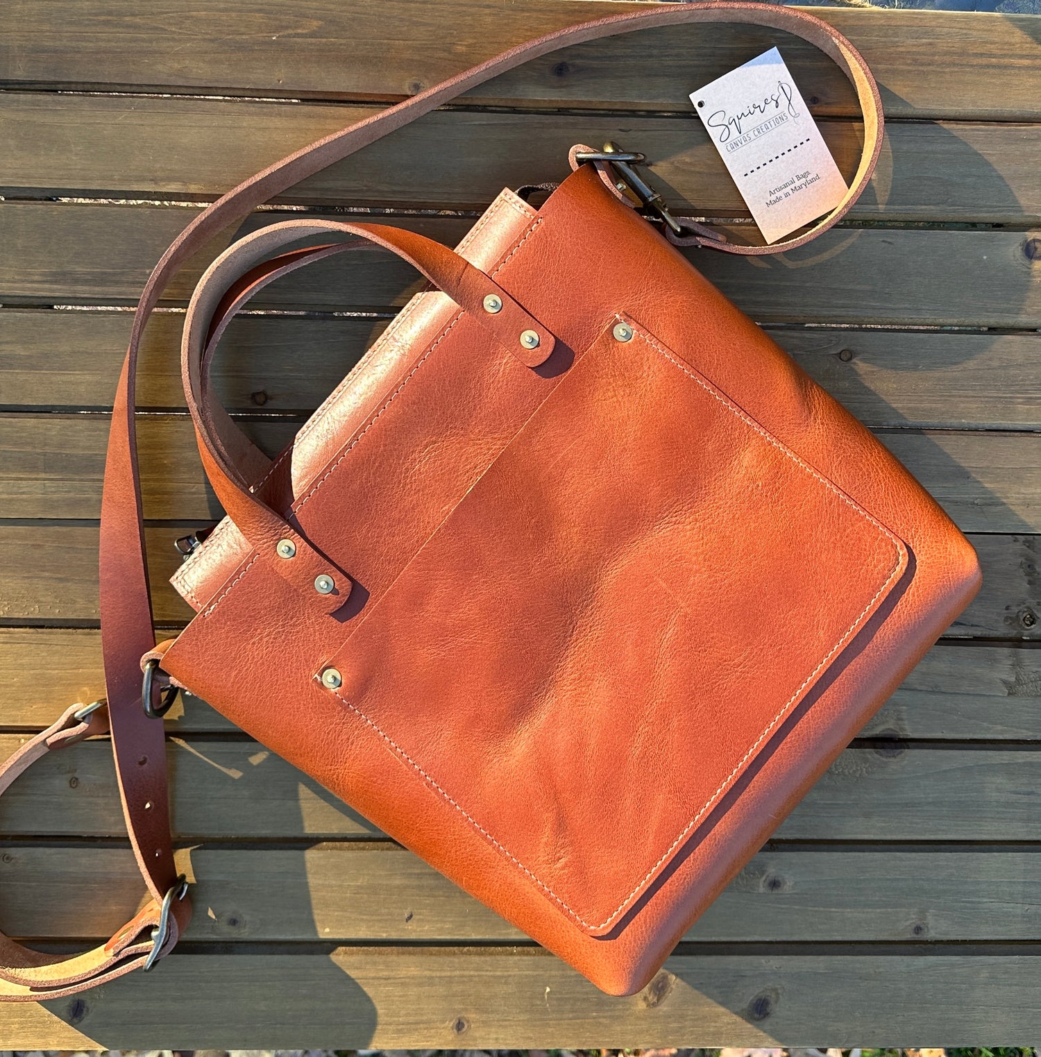 Flat view of the Cherry West Street Crossbody bag made with vegetable-tanned leather.