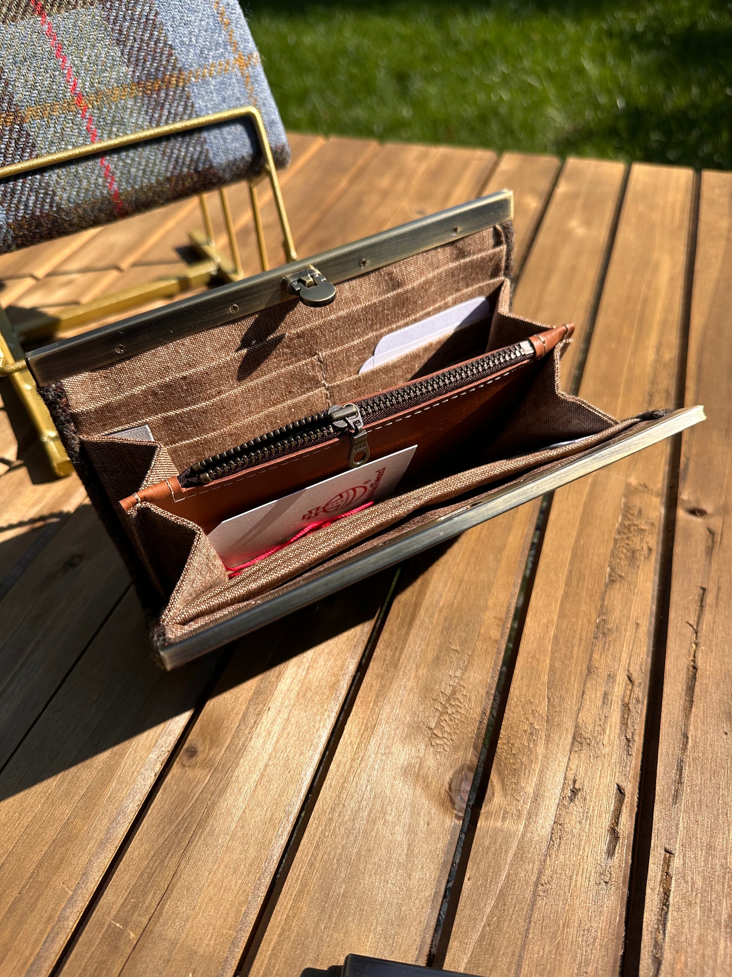 Interior view of the open Harris Tweed® Large Rock Hall Wallet, highlighting the organization features: card slots, cash slip pocket, and leather zipper coin pouch.