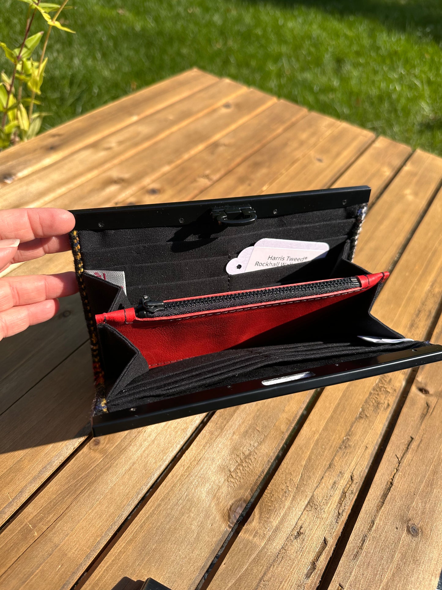 Interior view of the open Harris Tweed® Large Rock Hall Wallet, highlighting the organization features: card slots, cash slip pocket, and leather zipper coin pouch.
