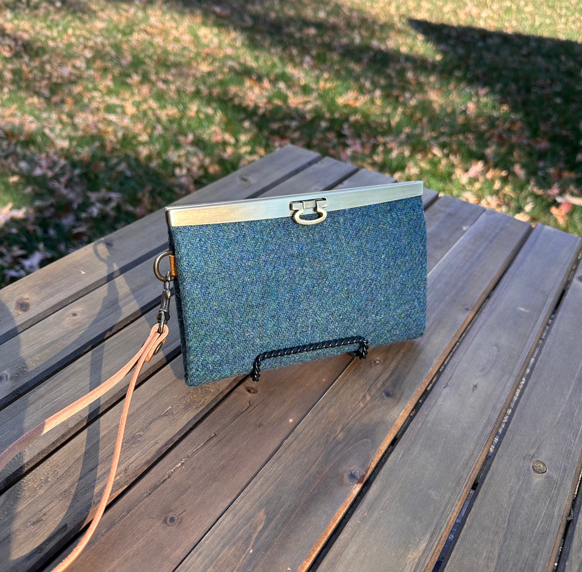 Closed Large Harris Tweed® Teal Twill Rock Hall Wallet features Antique Brass Hardware flip-lock closure.