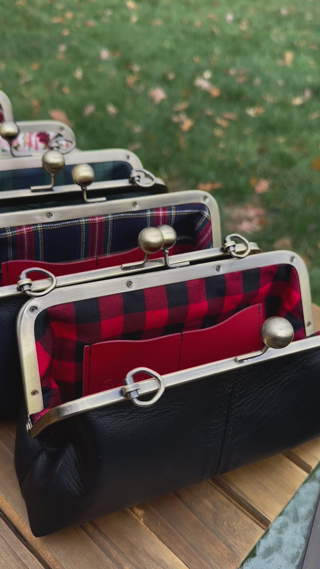 Collection of handcrafted leather kiss lock purses with bronze hardware and chain straps.  The interior of leather kiss lock purses with various colorful linings. Includes 2 card slots and space for phone and essentials. Compact and functional design. Wear as clutch, shoulder, or crossbody. Made in Maryland.