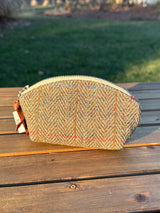 The Seashell Pouch in Green Mixed Herringbone  Harris Tweed® has a curved top and flat base that stands up on its own, lined with natural heavy canvas.