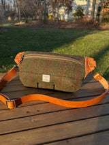 Minimalist sling bag handcrafted with Green plaid Harris Tweed® and Horween Sienna Leather, finished with Antique Brass hardware.