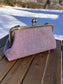 Harris Tweed® kiss lock purse in Pink & Blue Wide Herringbone with bronze hardware. Wear as a clutch, attach chain for shoulder or crossbody wear. Holds phone, cards, and small items. Timeless design handcrafted in Maryland. 