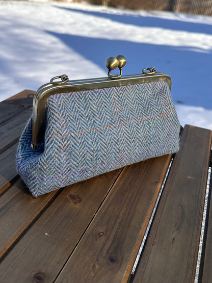 Harris Tweed® kiss lock purse in Blue Herringbone with bronze hardware. Wear as a clutch, attach chain for shoulder or crossbody wear. Holds phone, cards, and small items. Timeless design handcrafted in Maryland. 