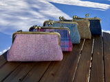 Collection of handcrafted Harris Tweed® kiss lock purses with bronze hardware. Classic clutch style with 2 card slots, fits a phone and small essentials. Wear as a clutch, shoulder bag, or crossbody. Made in Maryland, perfect for special occasions.