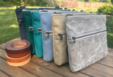Collection of handcrafted Canvas Bayside Slim Crossbody Bags in  waxed canvas, and solid canvas styles, with full canvas lining and adjustable vegetable-tanned leather straps.