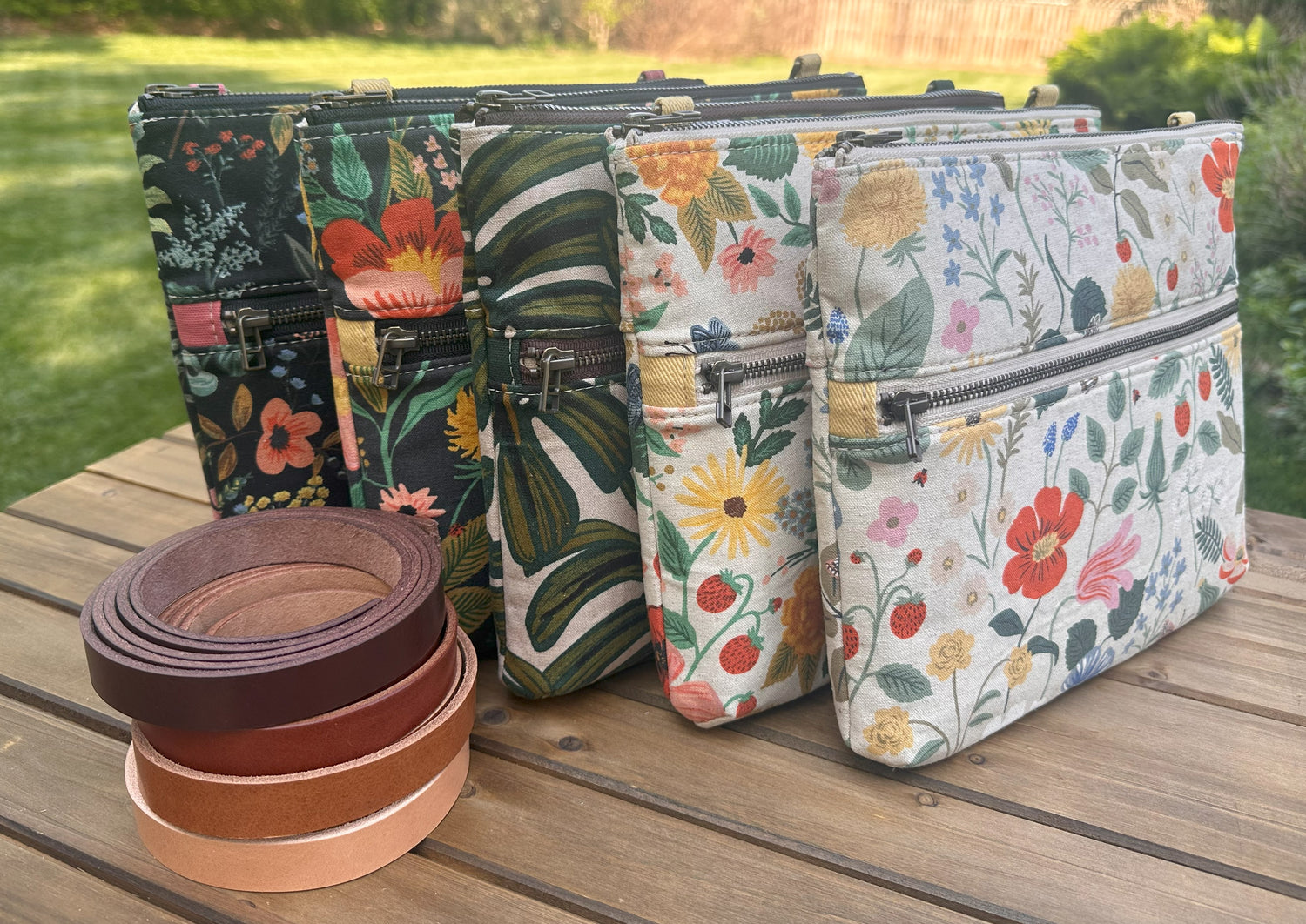 Collection of handcrafted Canvas Bayside Slim Crossbody Bags in Rifle Paper Co canvas styles, with full canvas lining and adjustable vegetable-tanned leather straps.